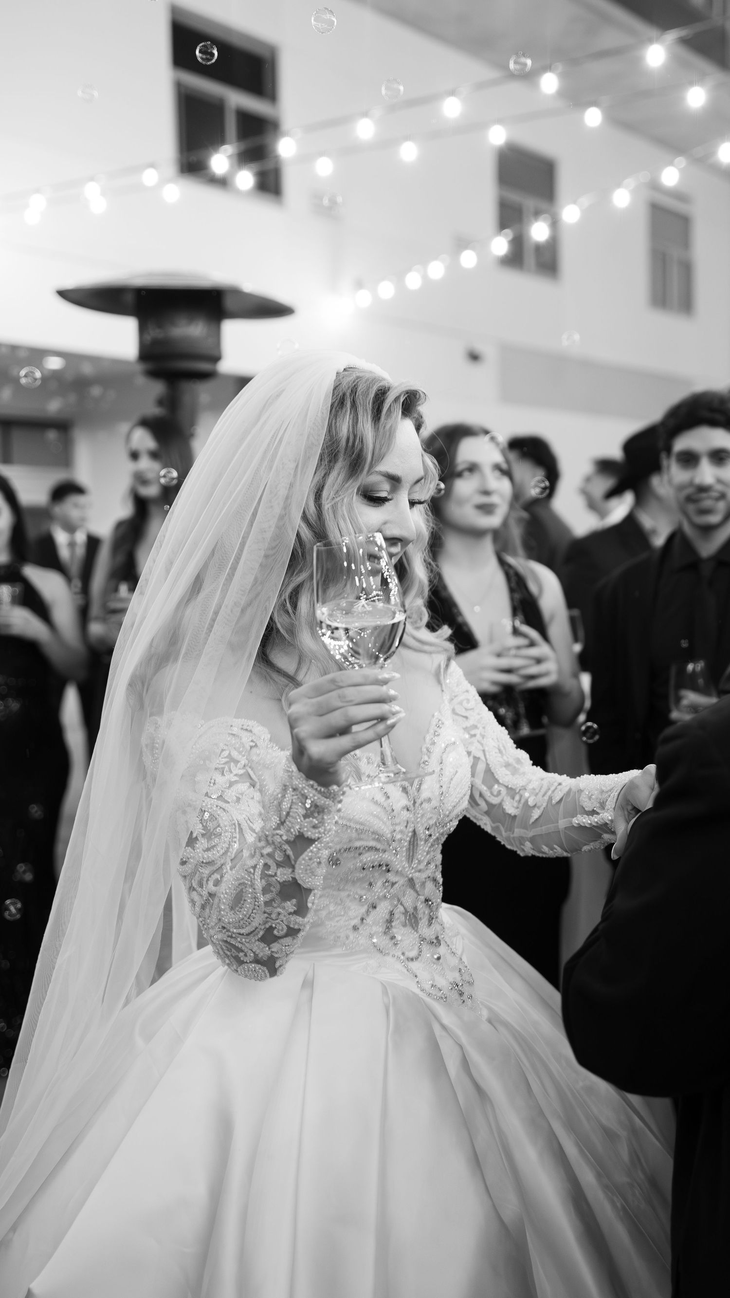 A bride in a lace ballgown twirls on the dance floor during her wedding reception.