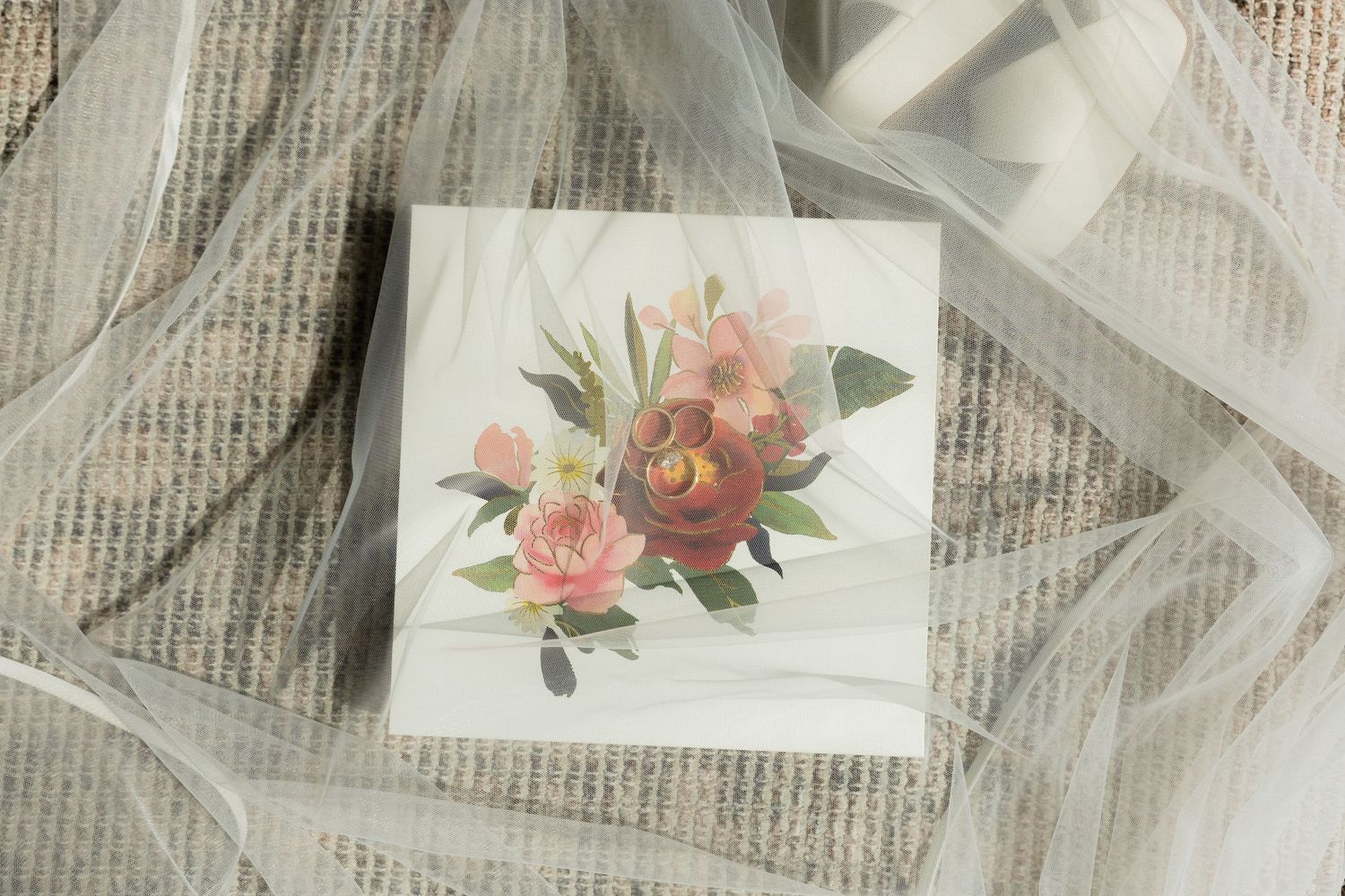 White gift box with elegant floral arrangement featuring dark red roses and pink blooms, surrounded by sheer ribbon.