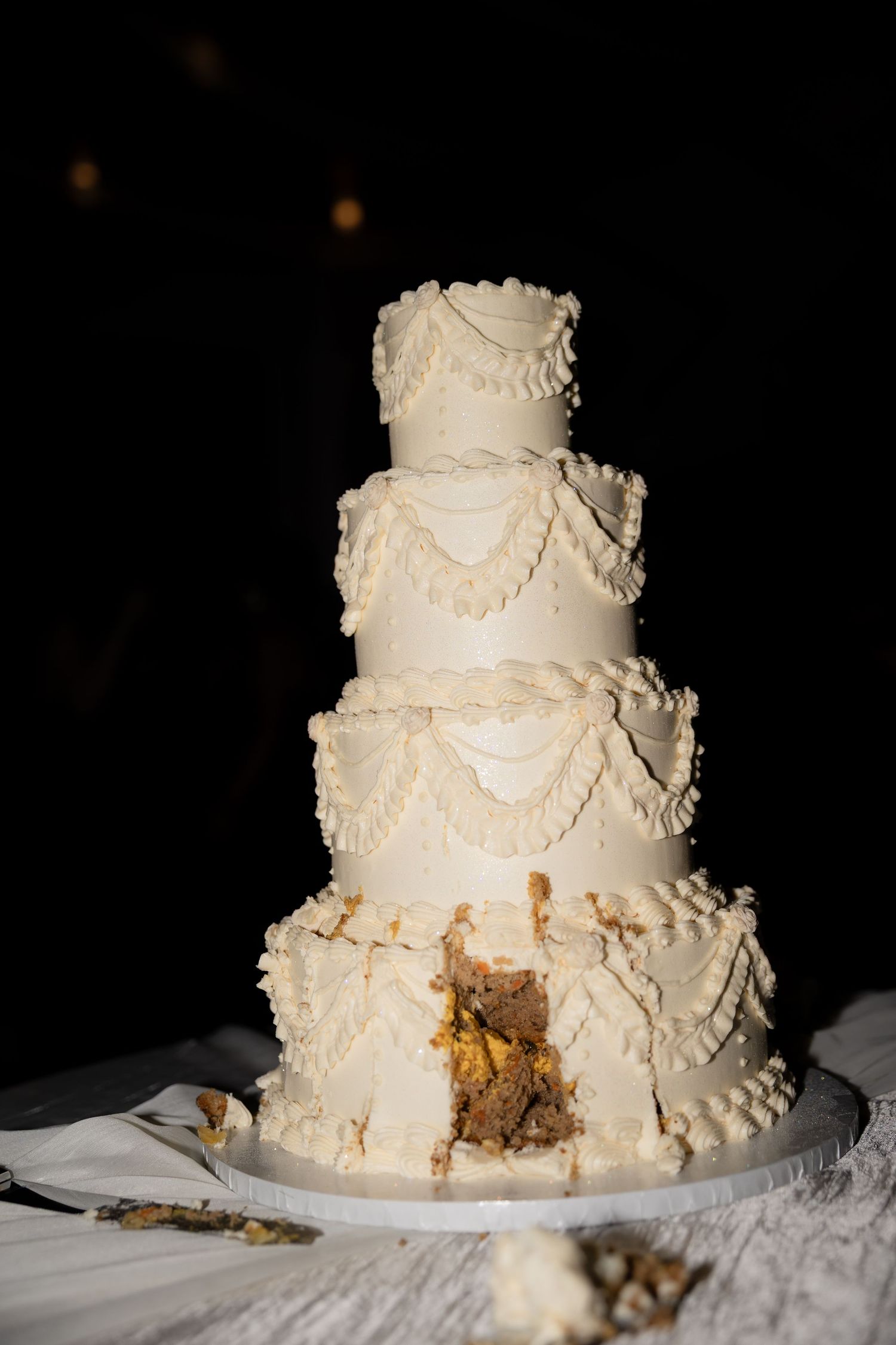 Elegant white wedding cake with textured frosting and delicate details on display.