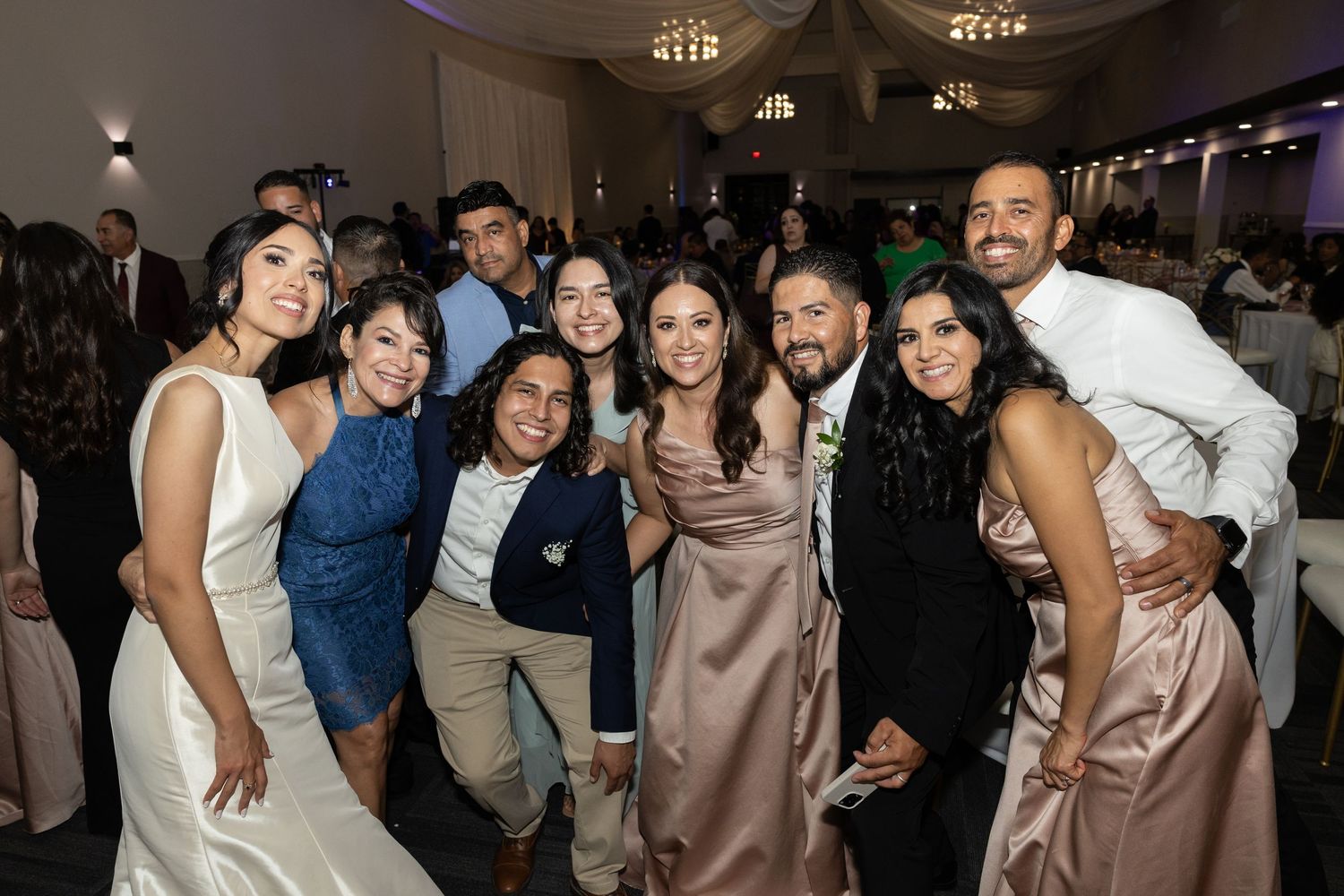 Guests enjoying themselves on a dimly lit dance floor during a wedding celebration.