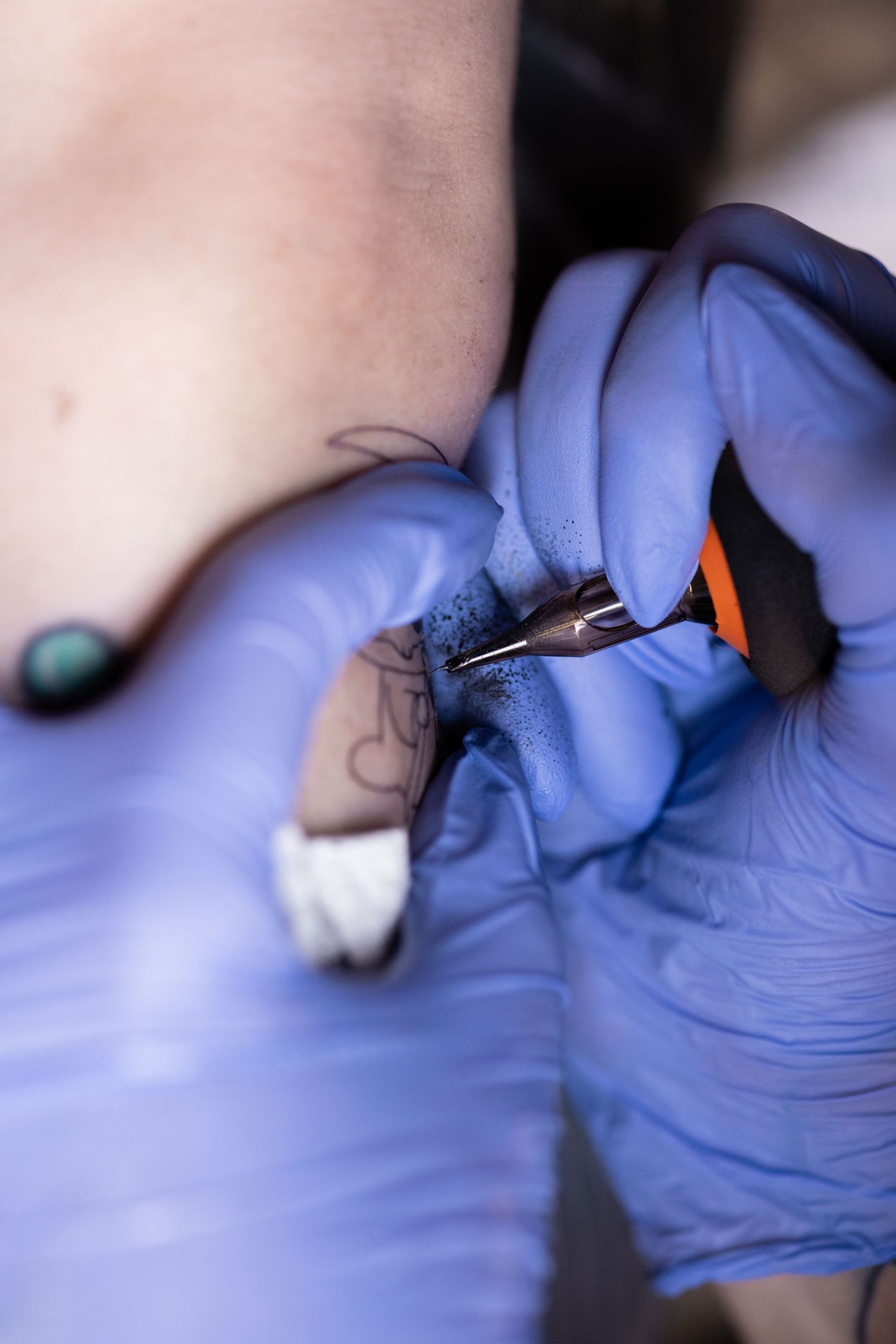 Close-up shot of hands in blue medical gloves performing detailed work.