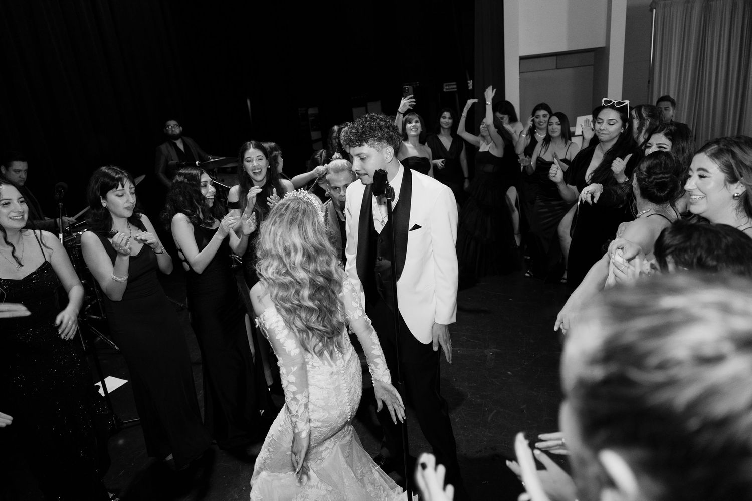 Wedding reception dance floor with guests celebrating in black and white photography.
