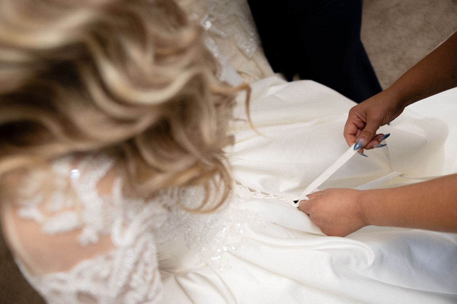 Close-up detail of intricate beadwork and embellishments on a white wedding dress bodice.