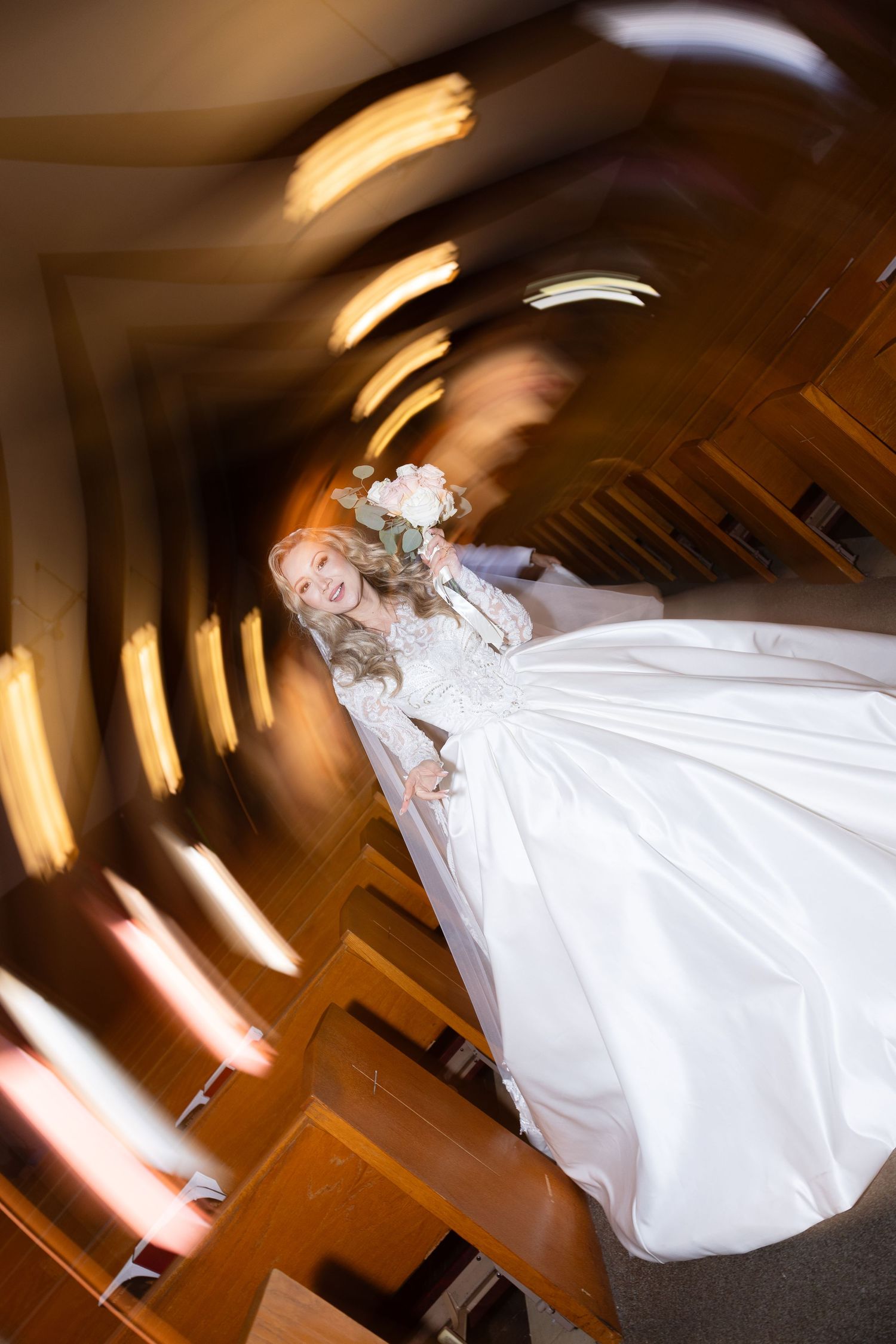 Artistic spinning photo of bride in flowing white gown with light streaks.