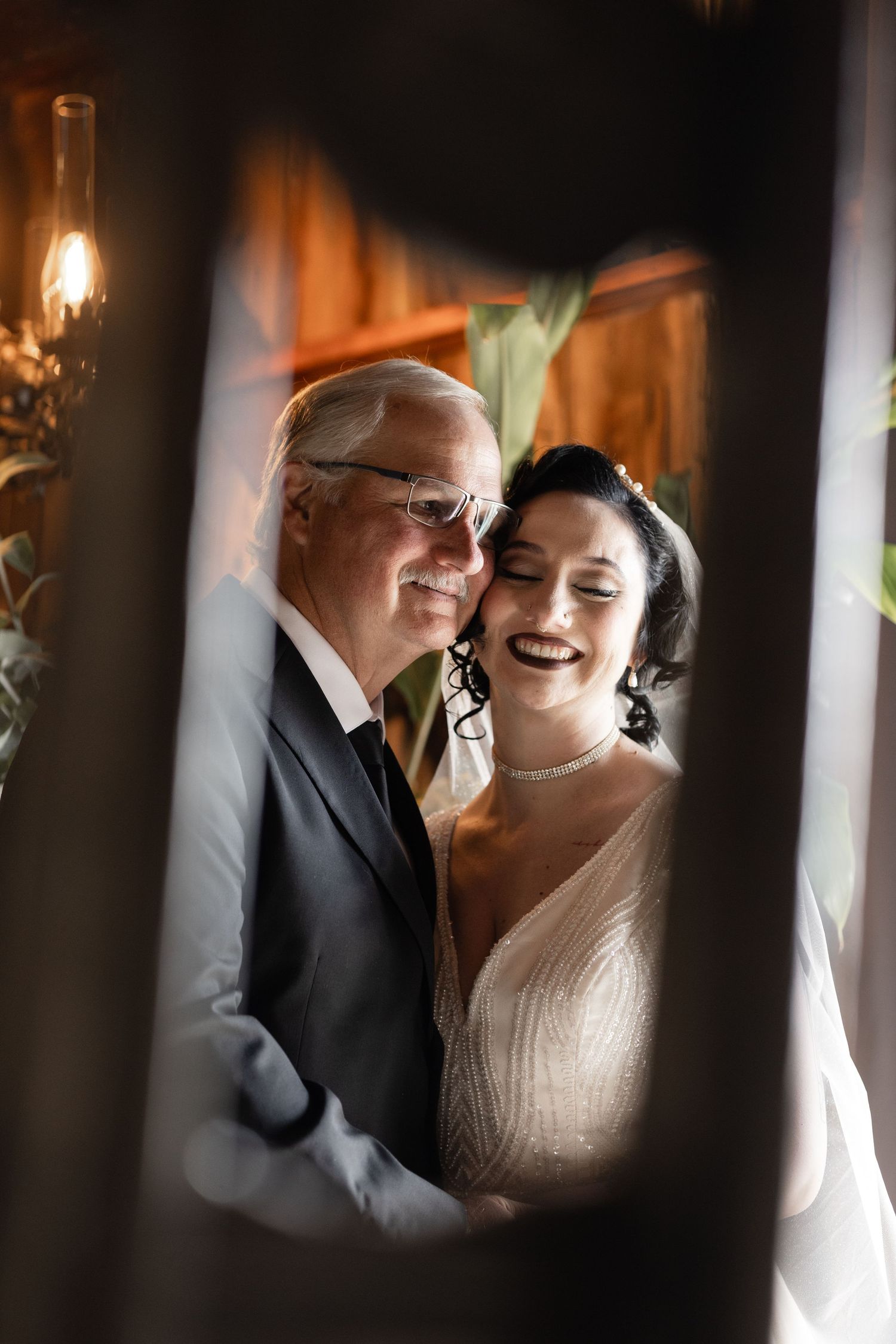 Candid wedding moment captured through decorative window frames with natural light.