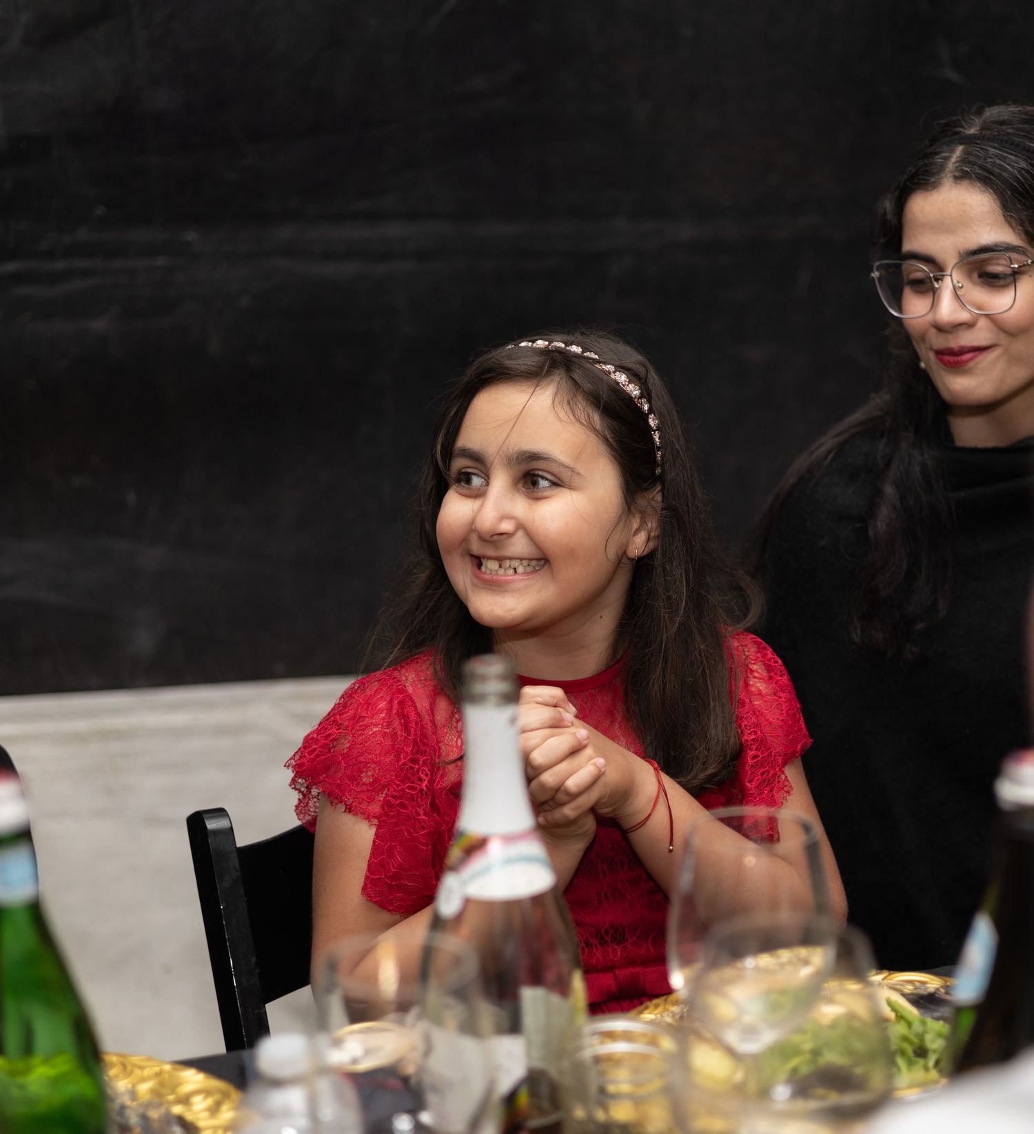 Wedding guests enjoying dinner and conversation at a decorated table with red accents.