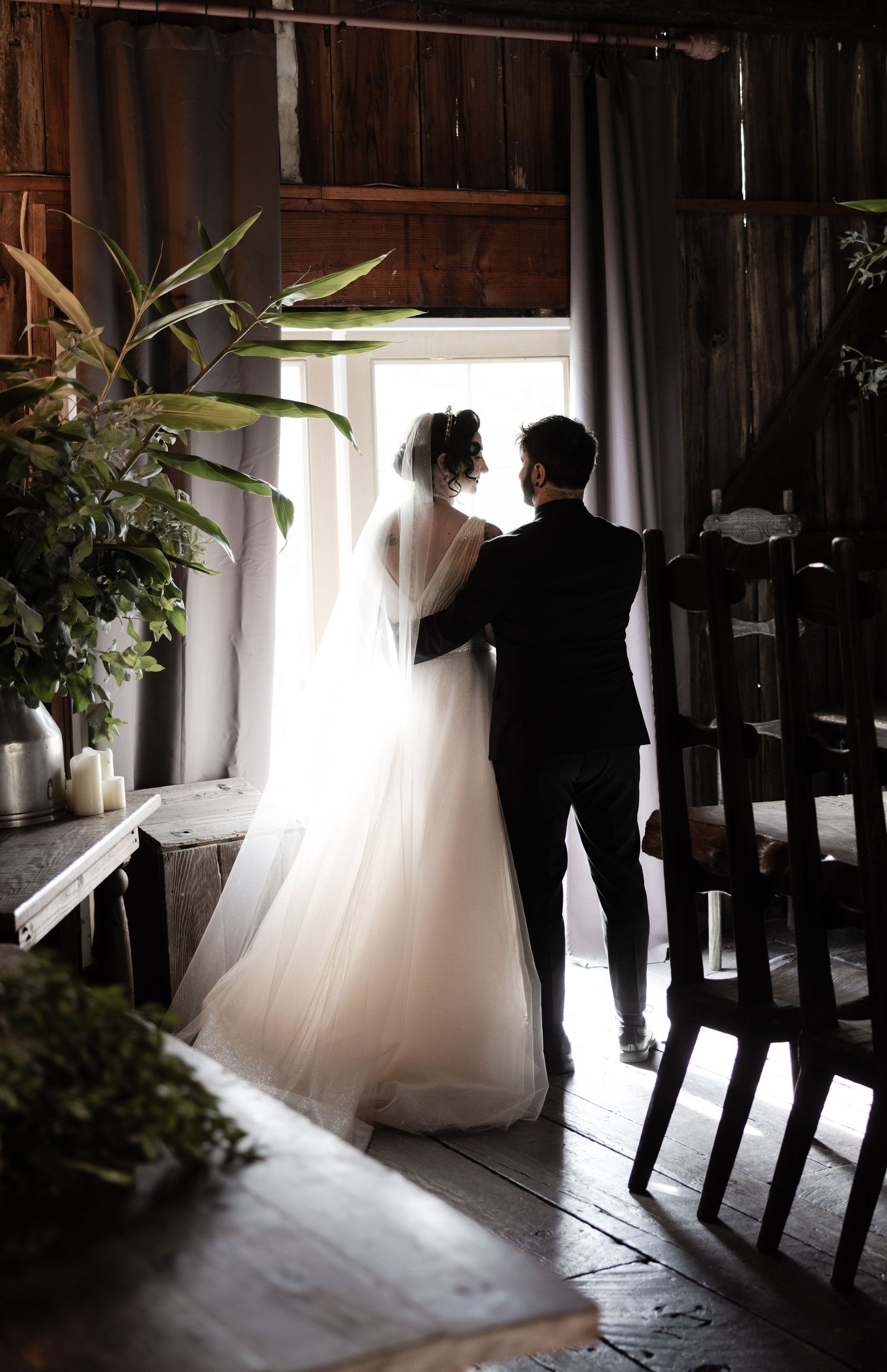 Silhouettes in a rustic barn with dramatic backlighting through doorway.