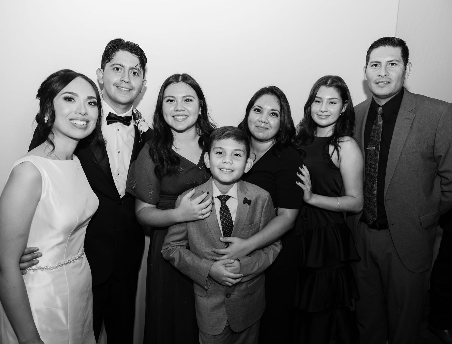 Black and white photo of wedding guests posing together at a formal reception.