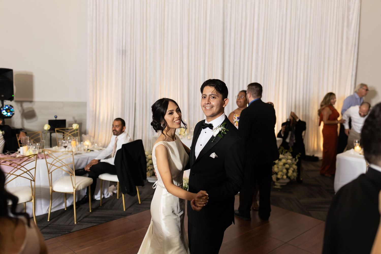 Wedding couple shares a romantic dance together on their special day at an elegant indoor reception venue.