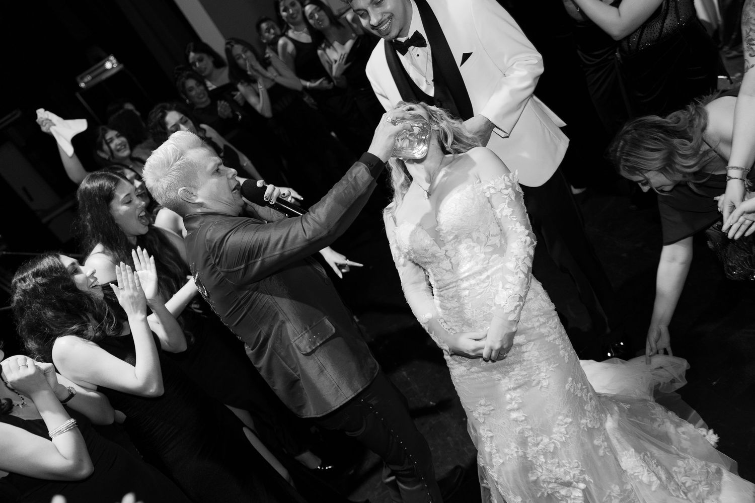 Candid moments of wedding guests dancing and celebrating at an evening reception.
