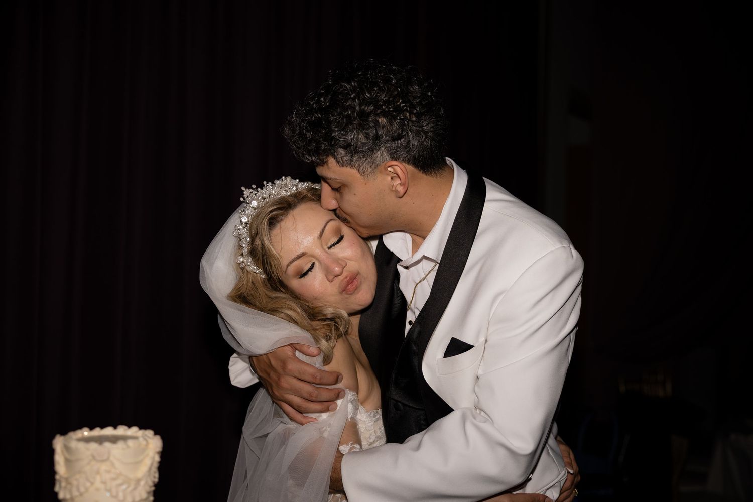 Romantic moment between newlyweds during their wedding cake cutting ceremony.