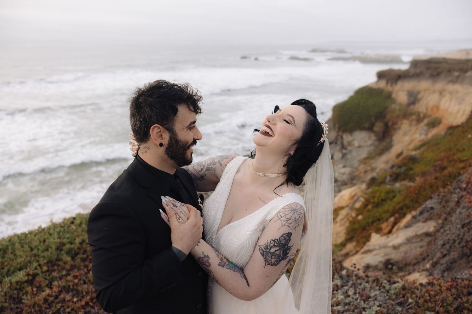 A joyful wedding moment captured on a dramatic clifftop overlooking the ocean.