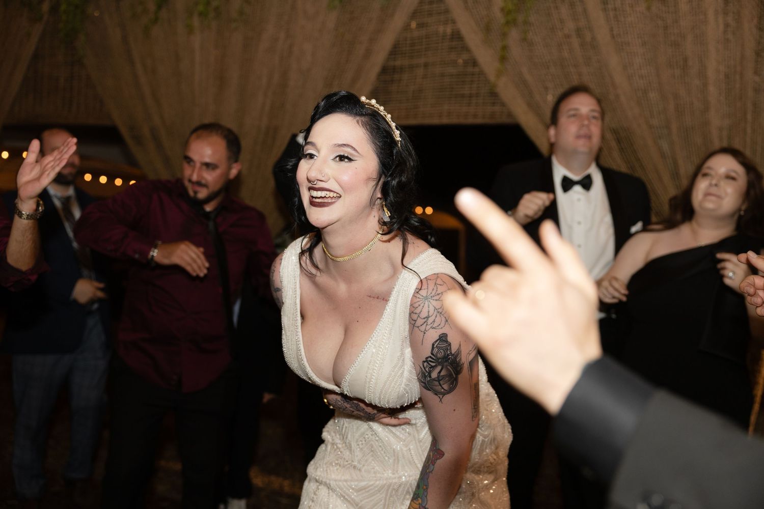 Energetic dancing and celebration during a rustic indoor wedding reception.