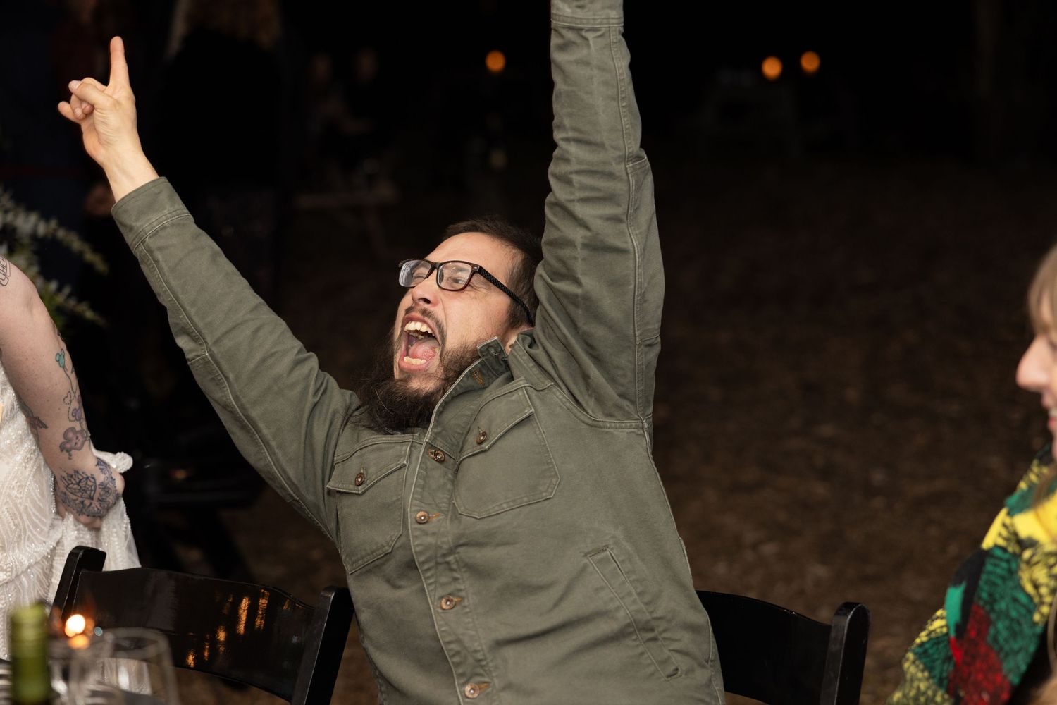 Celebratory moment at nighttime event with guests raising arms in excitement.
