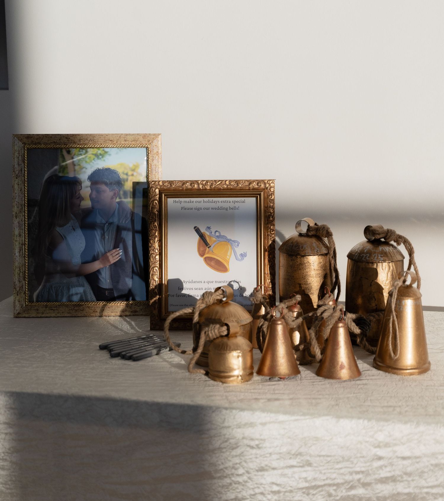 A collection of copper and brass kettles and framed photos arranged on a light gray surface.
