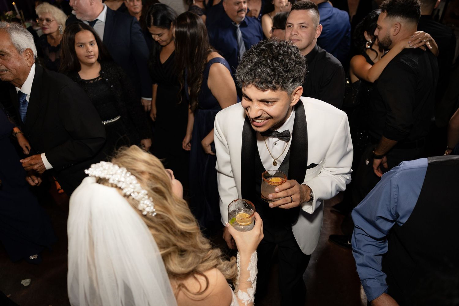 Wedding guests dancing and celebrating at a lively reception party.