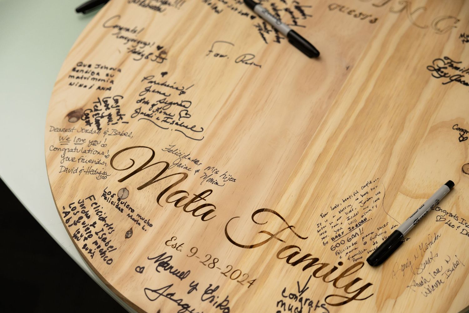 Wooden guest book with handwritten messages and signatures from wedding attendees.