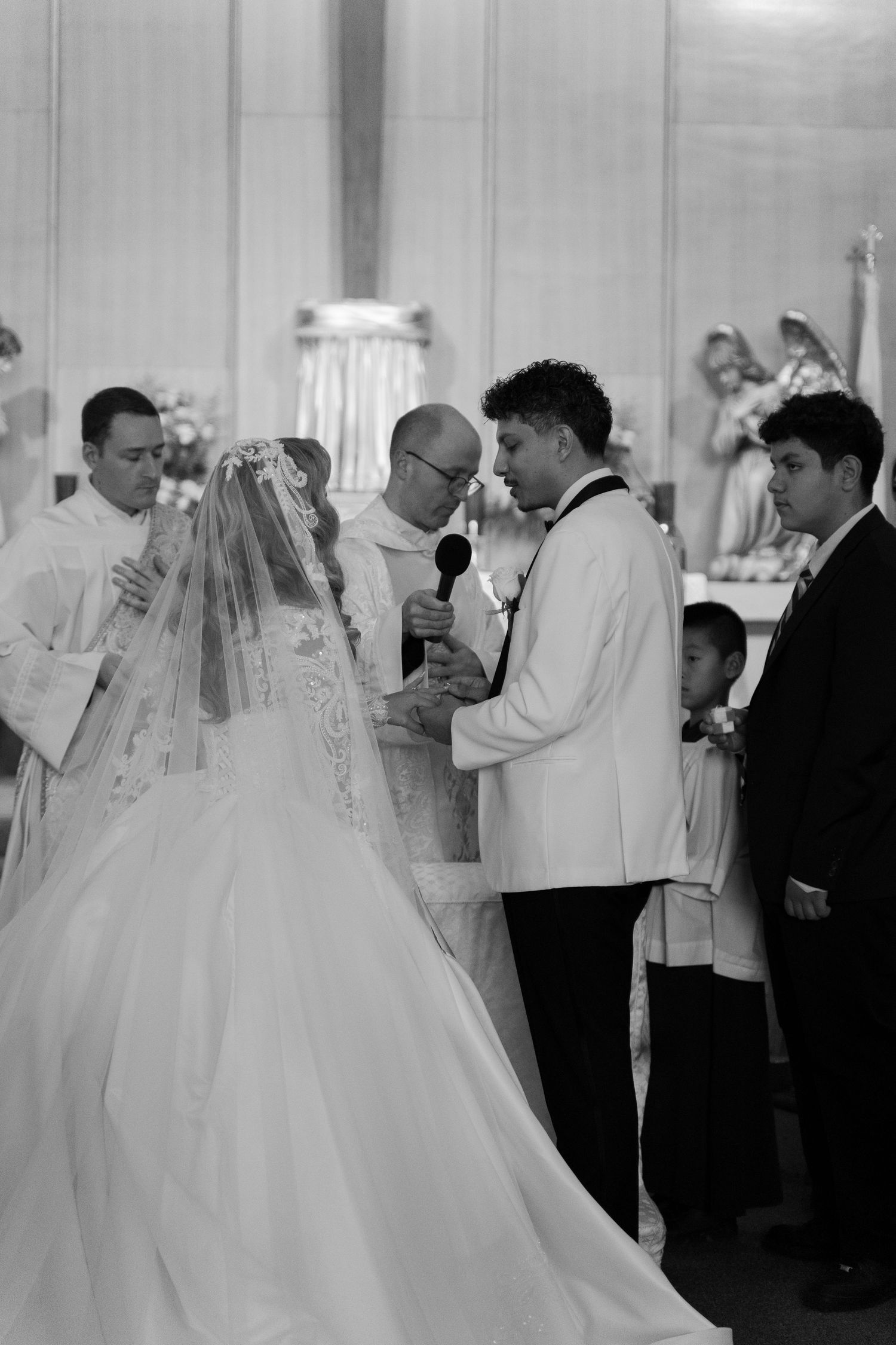A wedding ceremony in progress with a bride in a flowing white gown at the altar.