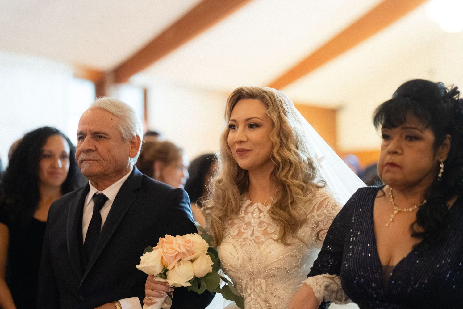 Wedding guests seated in church pews during ceremony.