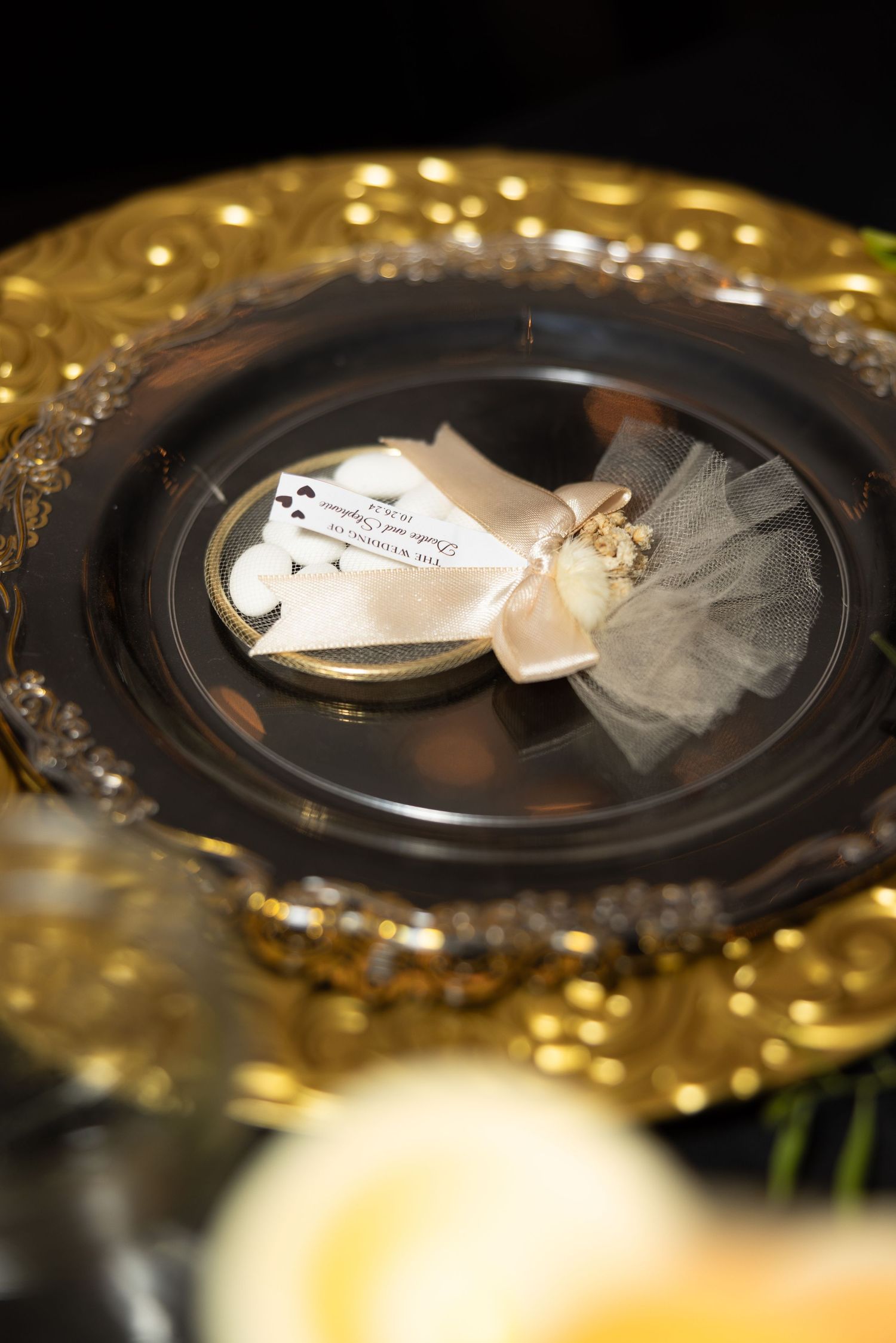 Decorative place settings with gold charger plates and tulle details at formal event.