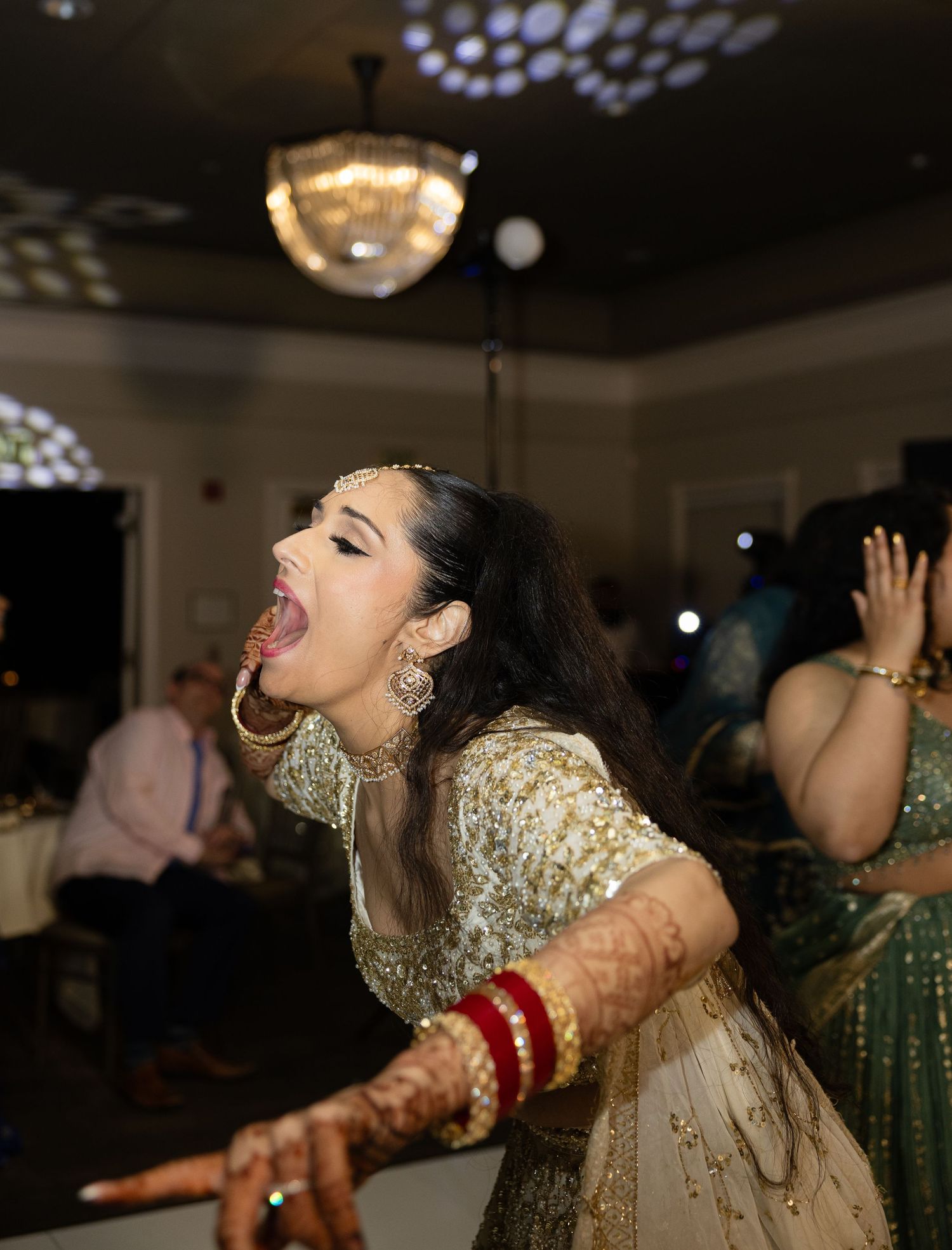 Wedding reception dance floor with people celebrating in traditional formal attire.