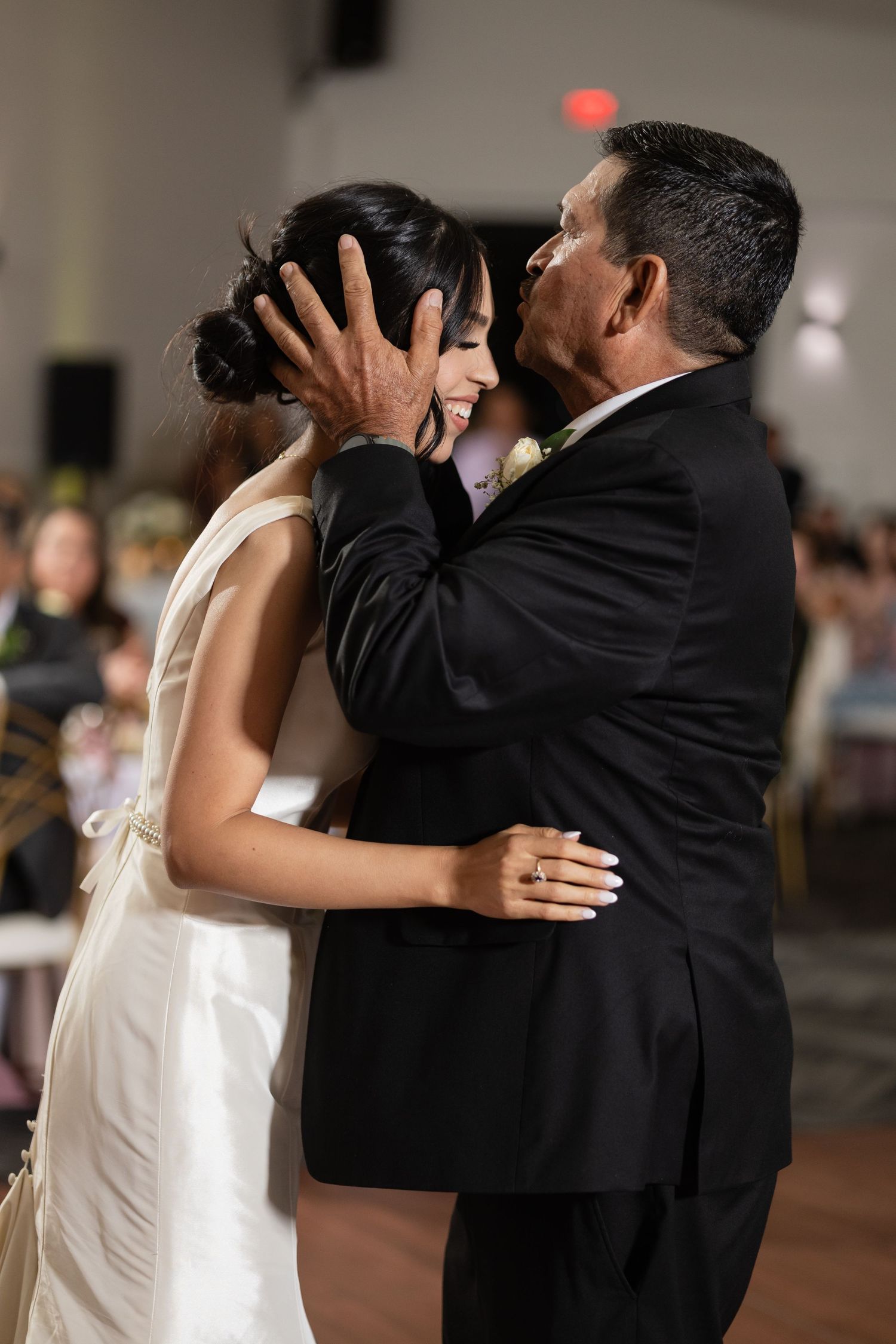 Wedding celebration featuring couples dancing closely together on a dimly lit dance floor.
