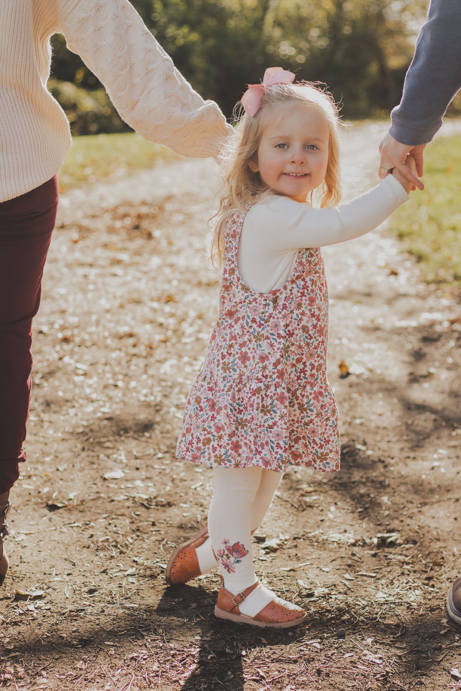Low angle view of feet and legs walking on a dirt path during a family photo session.