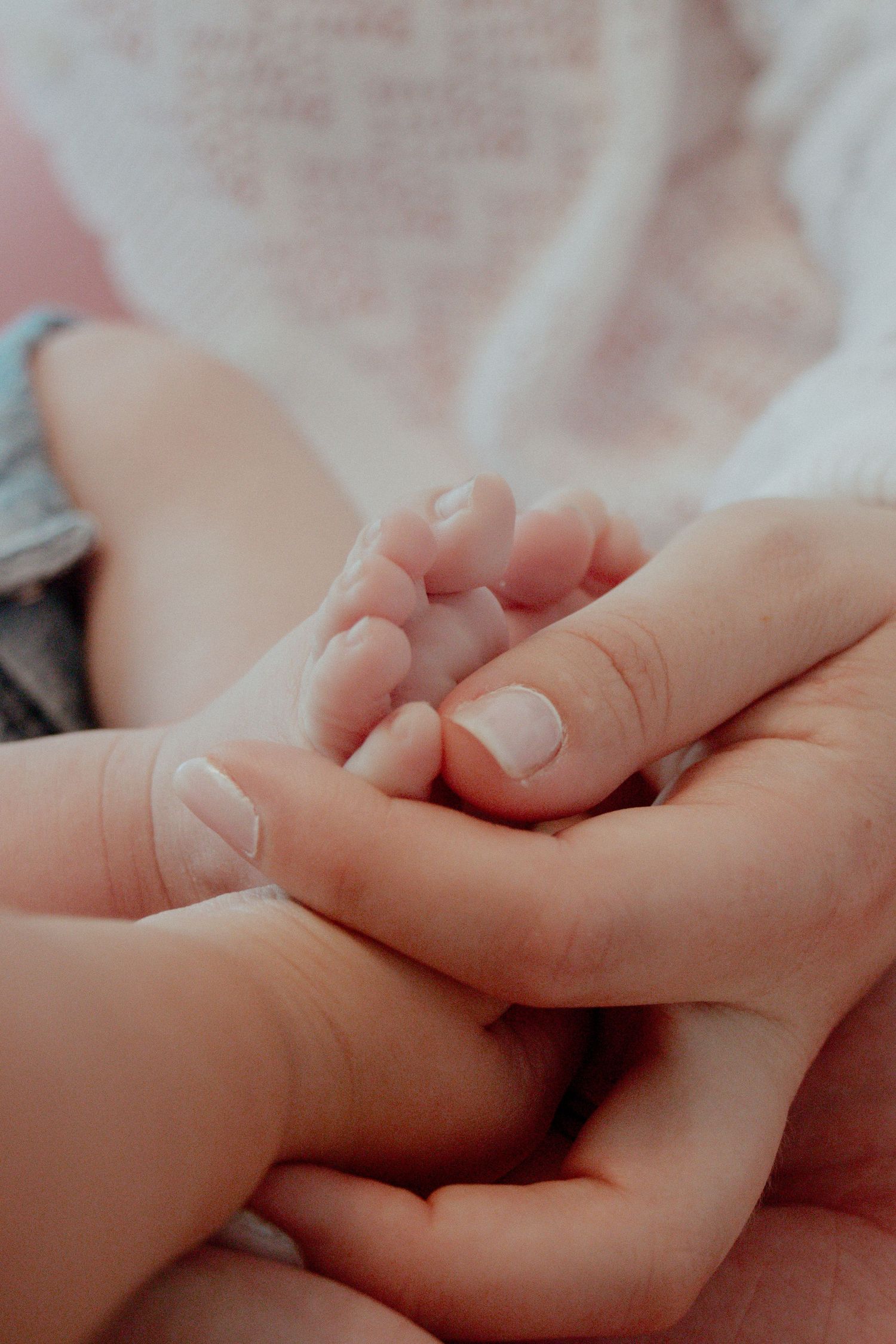 Close-up photograph of intertwined hands showing tender connection and intimacy.