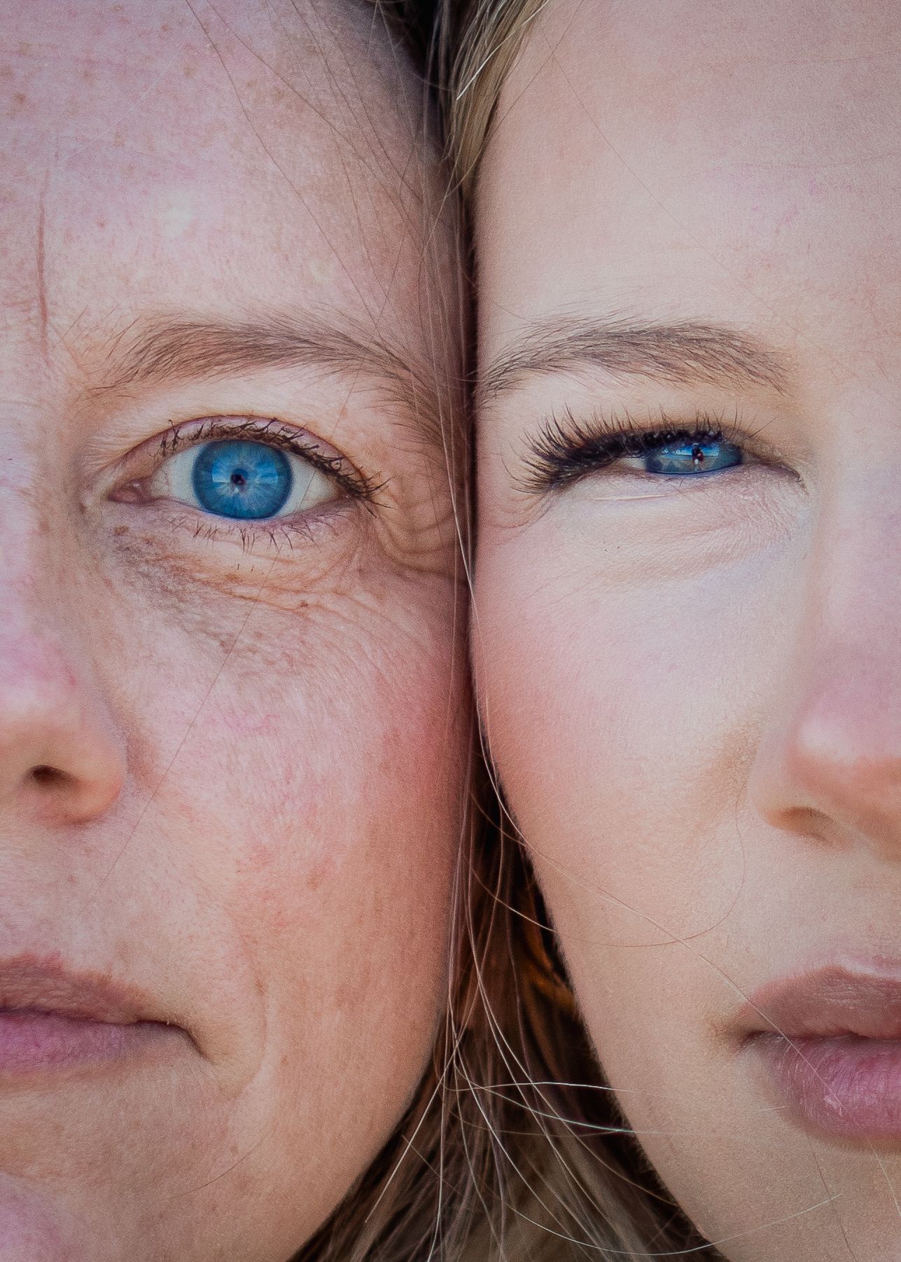 Close-up of two women with blue eyes, one older with wrinkles, one younger, faces pressed together.