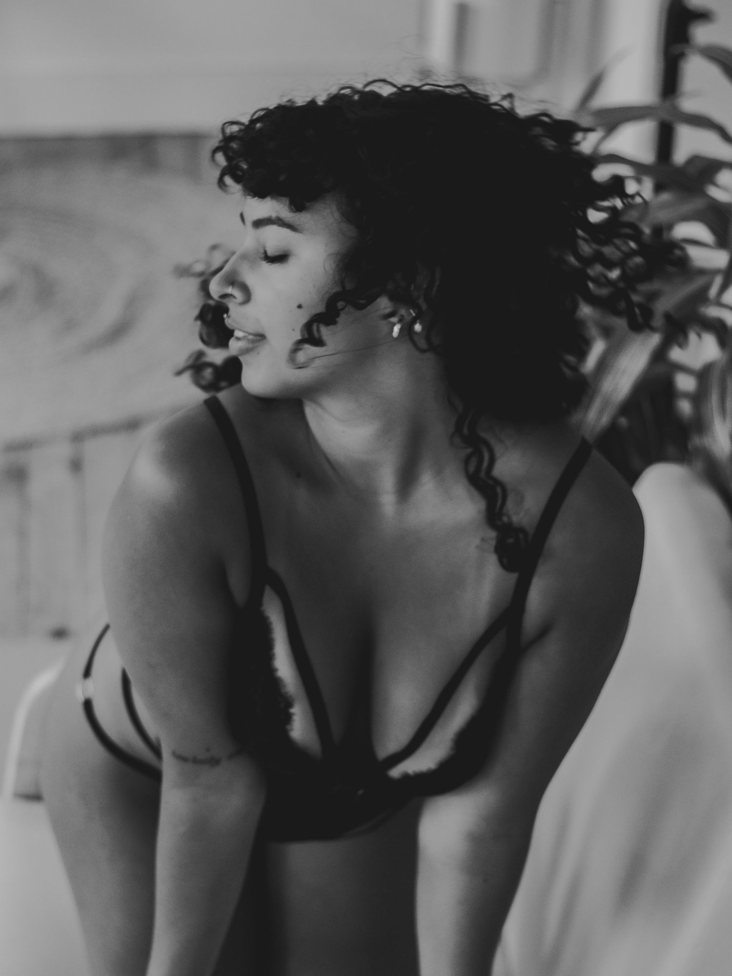 Artistic black and white boudoir photography with dramatic lighting and shadows.