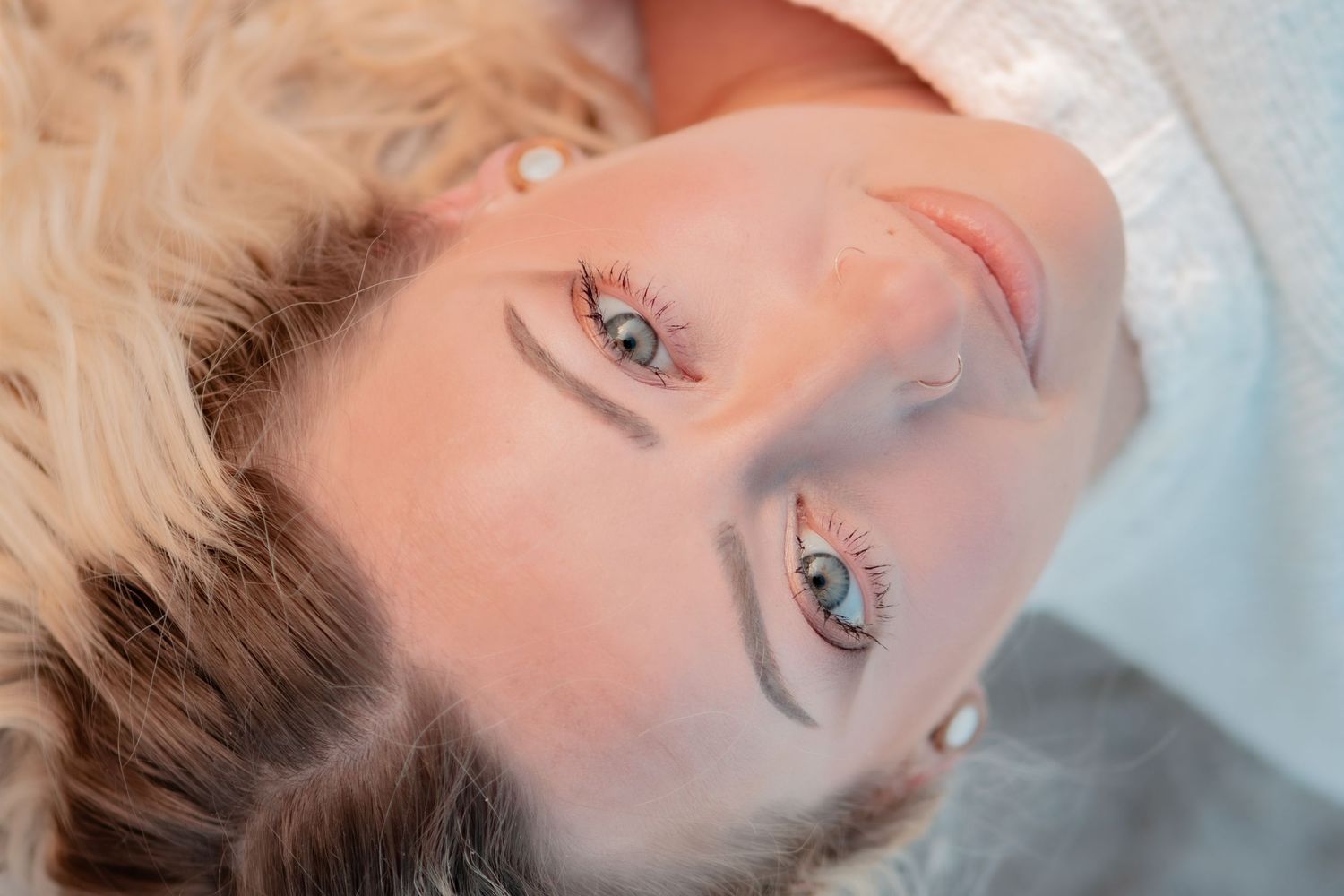 A series of close-up beauty shots showing soft glowing skin and blue eyes in ethereal lighting.