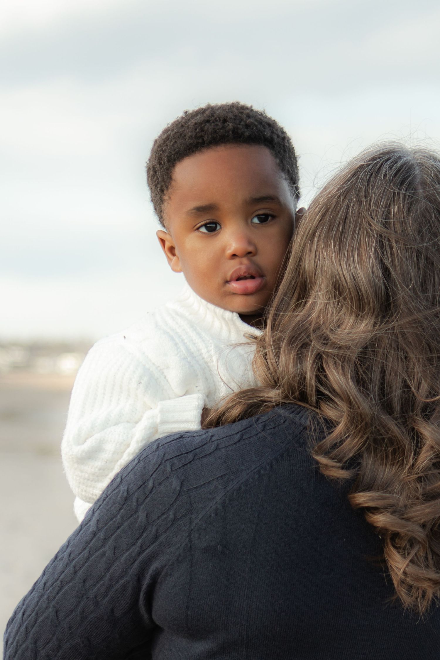 A sequence of tender moments showing a small child and adult embracing against a soft, bright background.