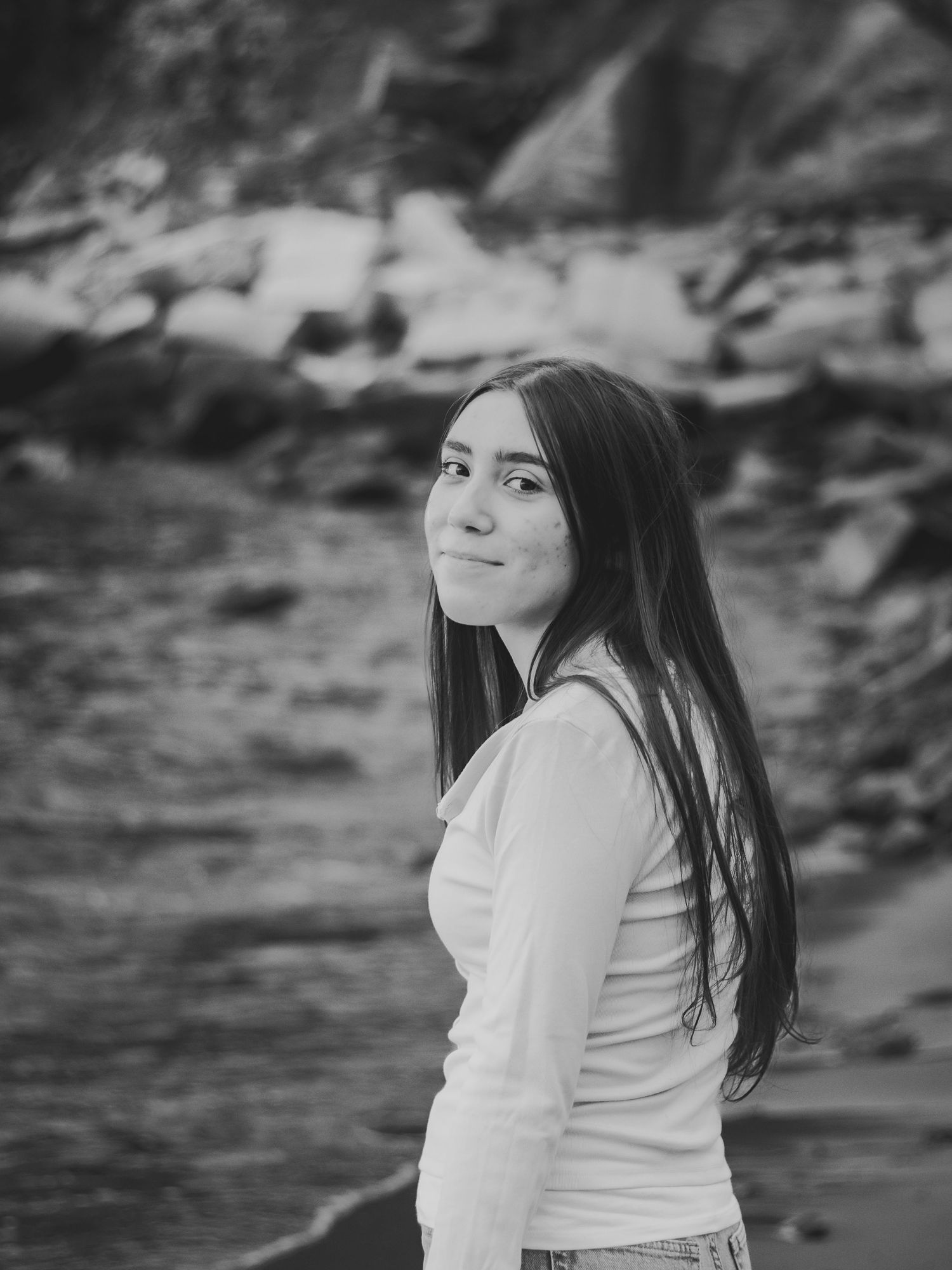 Black and white portrait session by rocky waterfront.