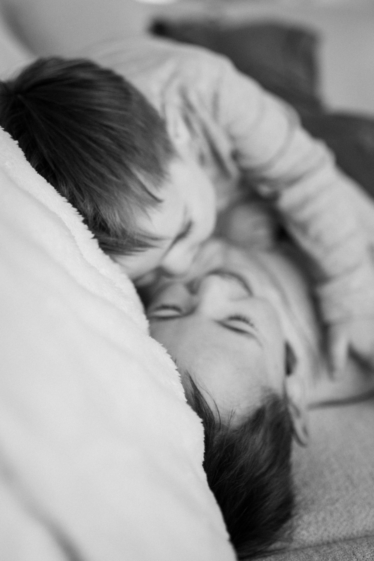 Series of peaceful black and white images showing childrens playing on soft couch.
Deux petits garçons chahutant et riant sur le canapé.