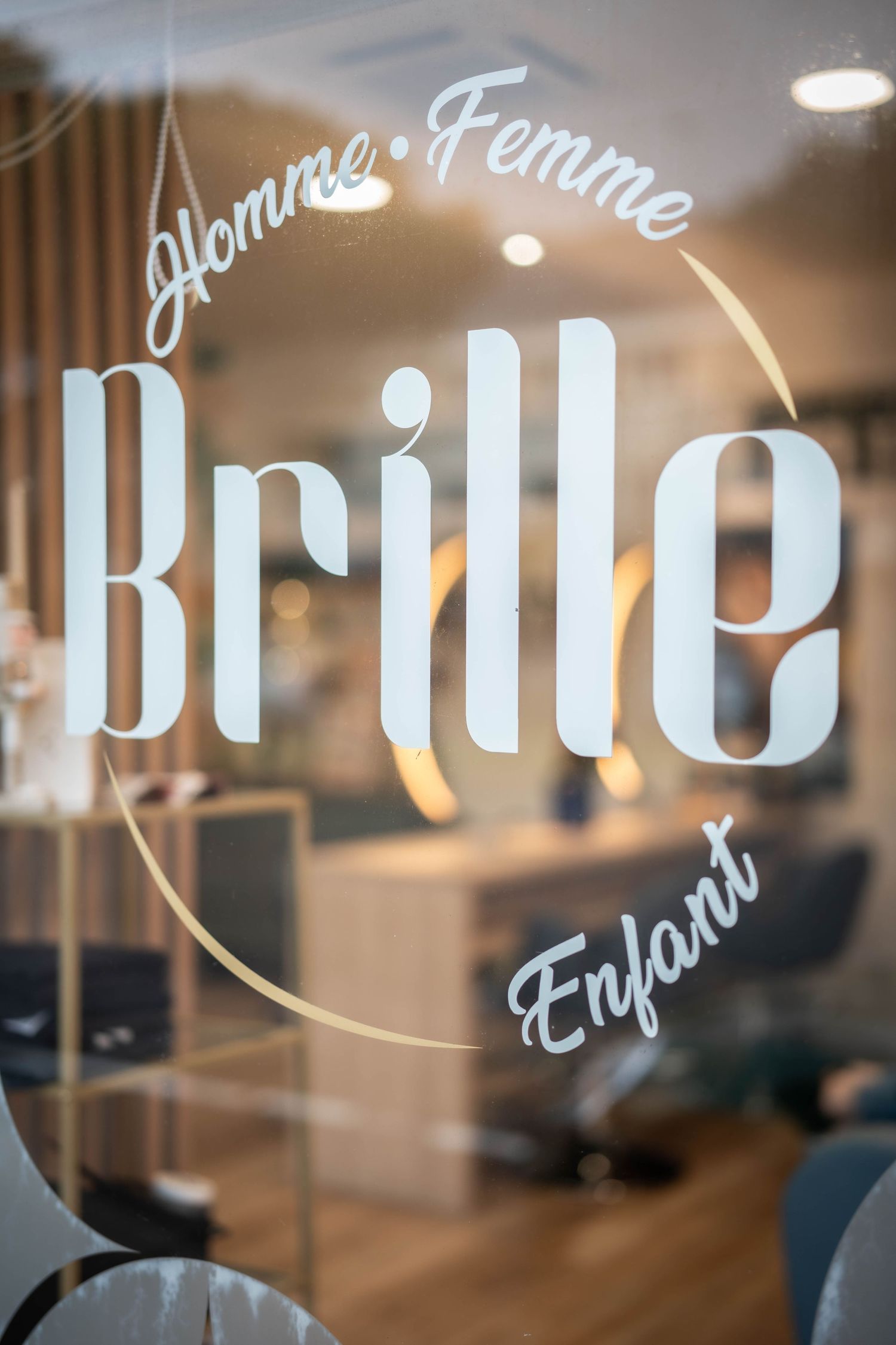 Close-up of frosted glass window displaying 'Brille' logo with elegant typography.
Devanture d'un salon de coiffure appelé 