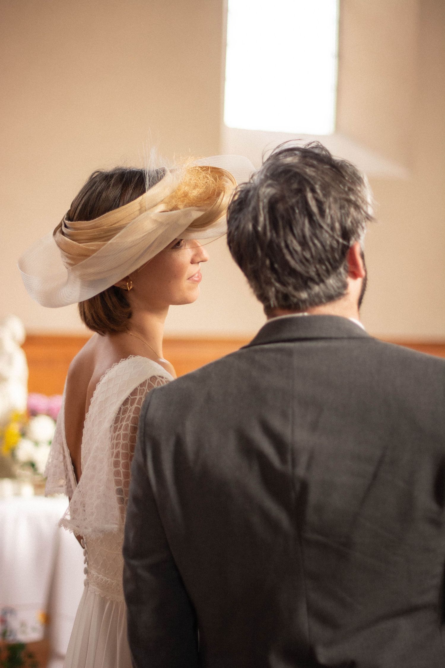 Dreamy profile shot of wedding guests with soft focus and warm lighting.
Mariée regardant son époux à l'église.