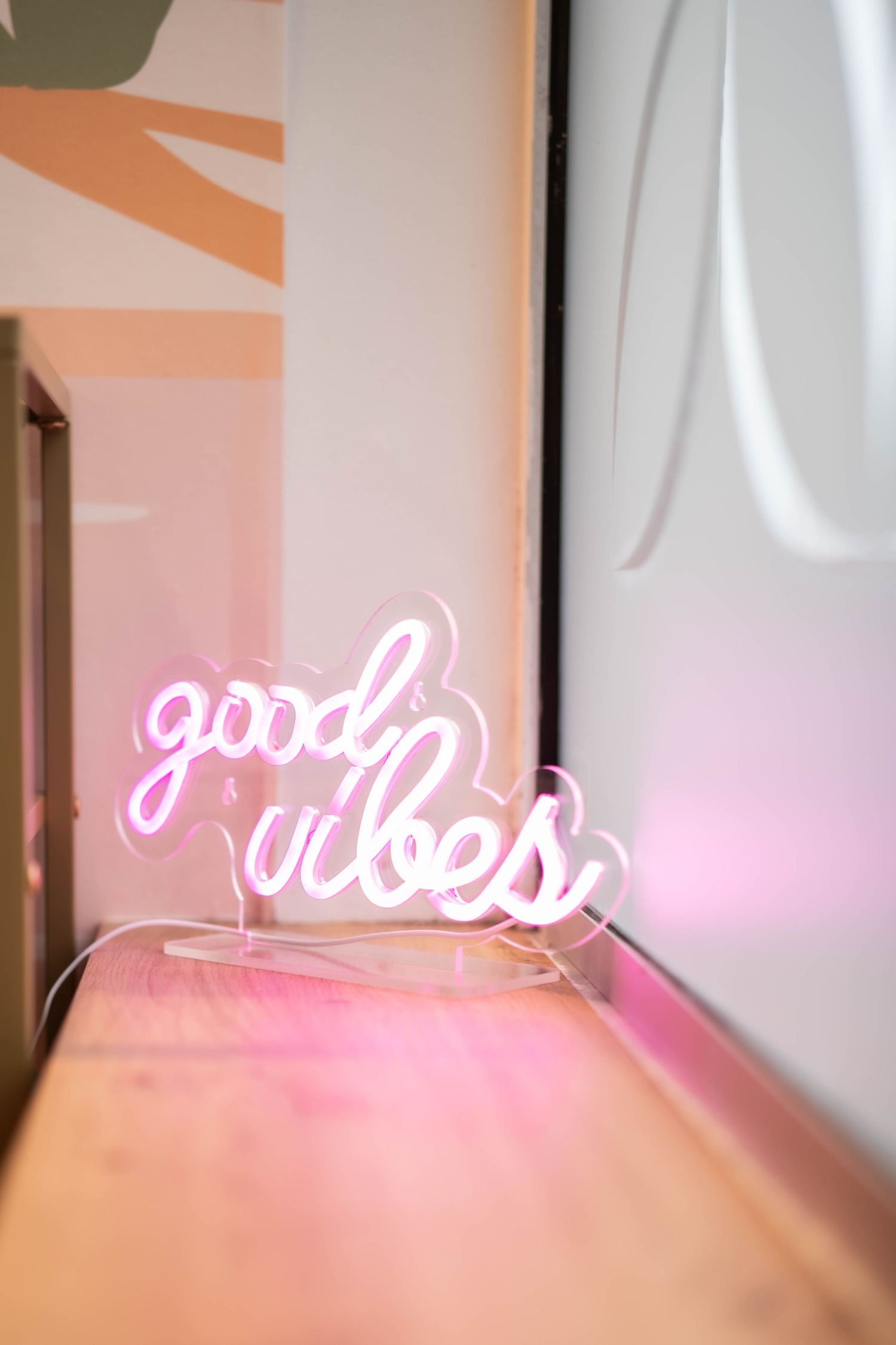 Pink neon light installation glowing on a white wall creating an artistic ambiance.
Néon rose 