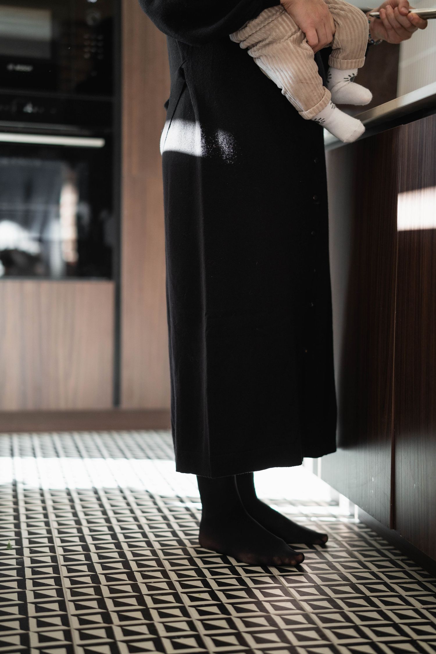 A sequence of low-angle shots showing feet and legs against a patterned floor.