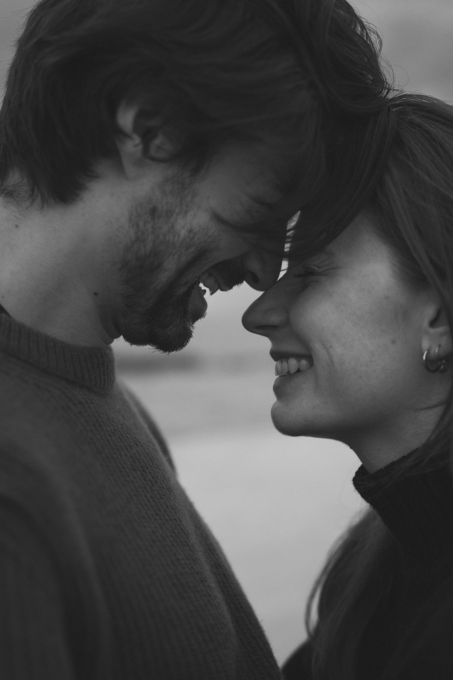 An intimate black and white portrait of a couple sharing a tender forehead touch.
Photo en noir et blanc d'un couple front contre front.