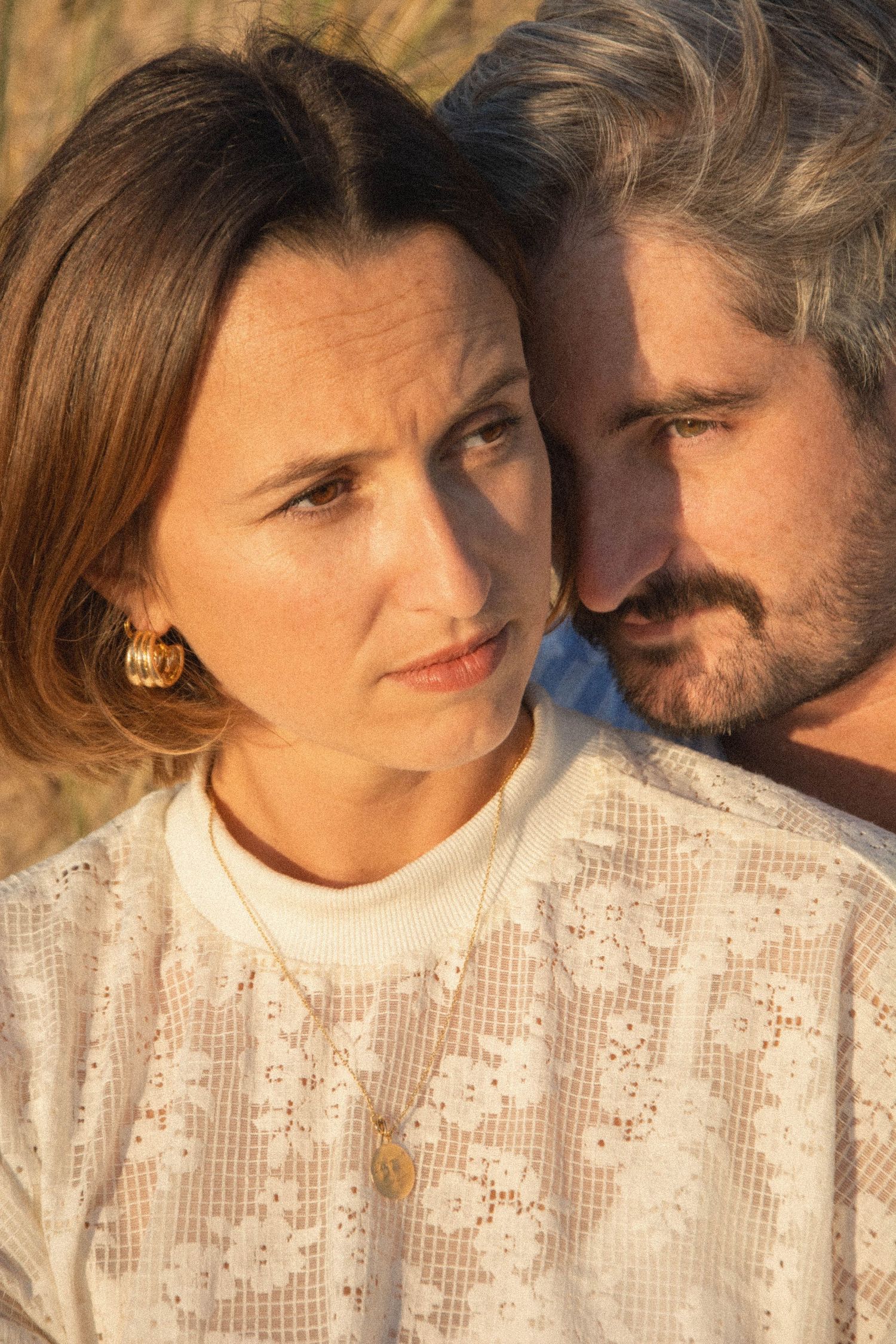An intimate close-up portrait of a couple in warm sunlight wearing casual attire.
Photo serrée sur les visage d'un couple.