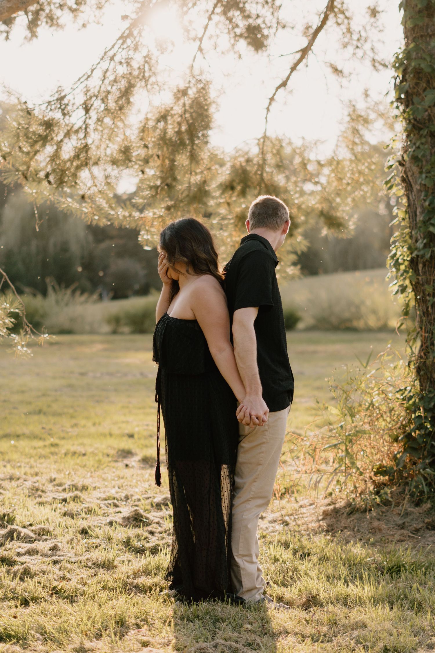 Couple shares a sweet moment in the field at Golden Hour.
