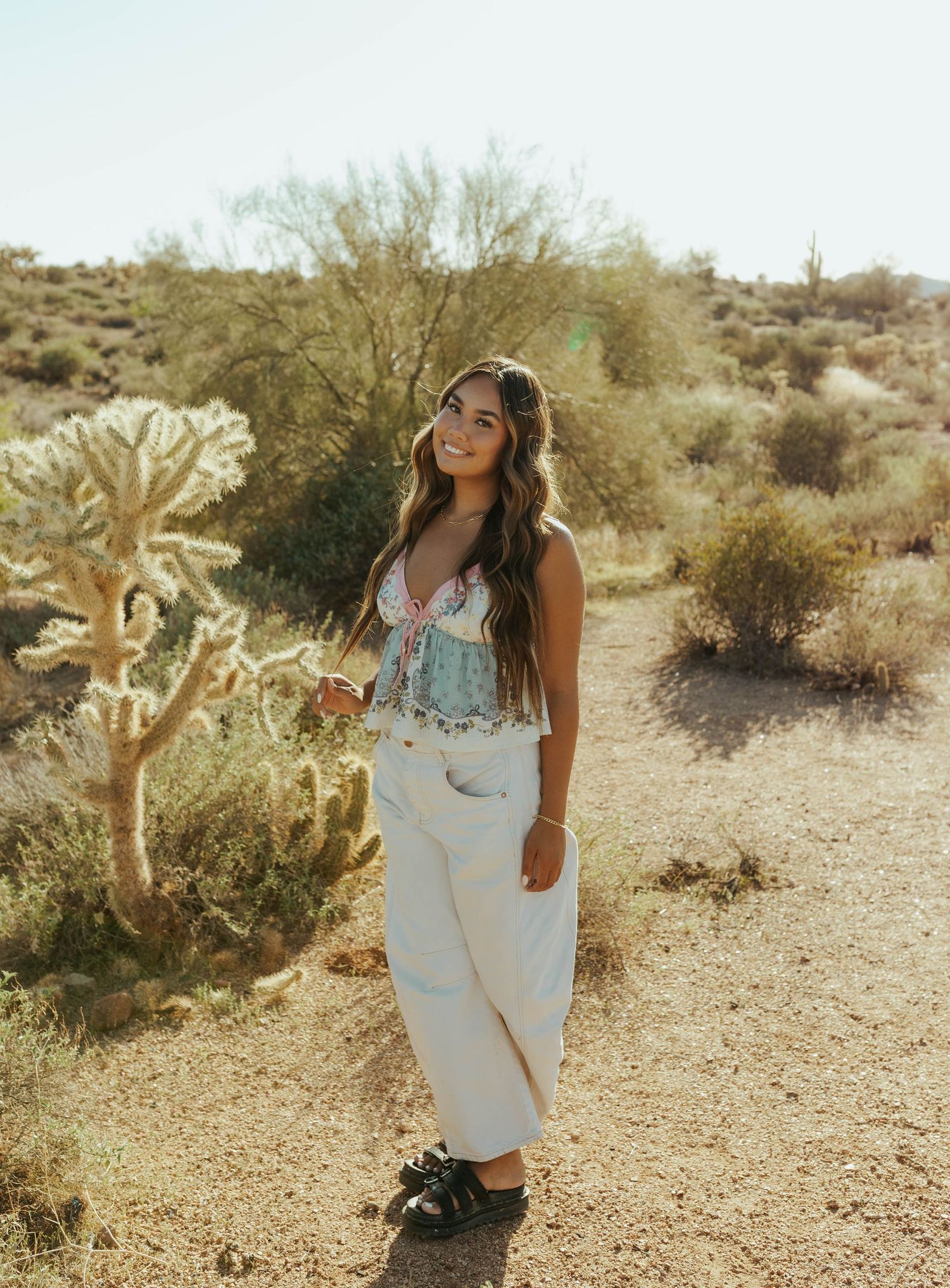 A desert portrait session featuring white clothing and floral details against a natural backdrop.