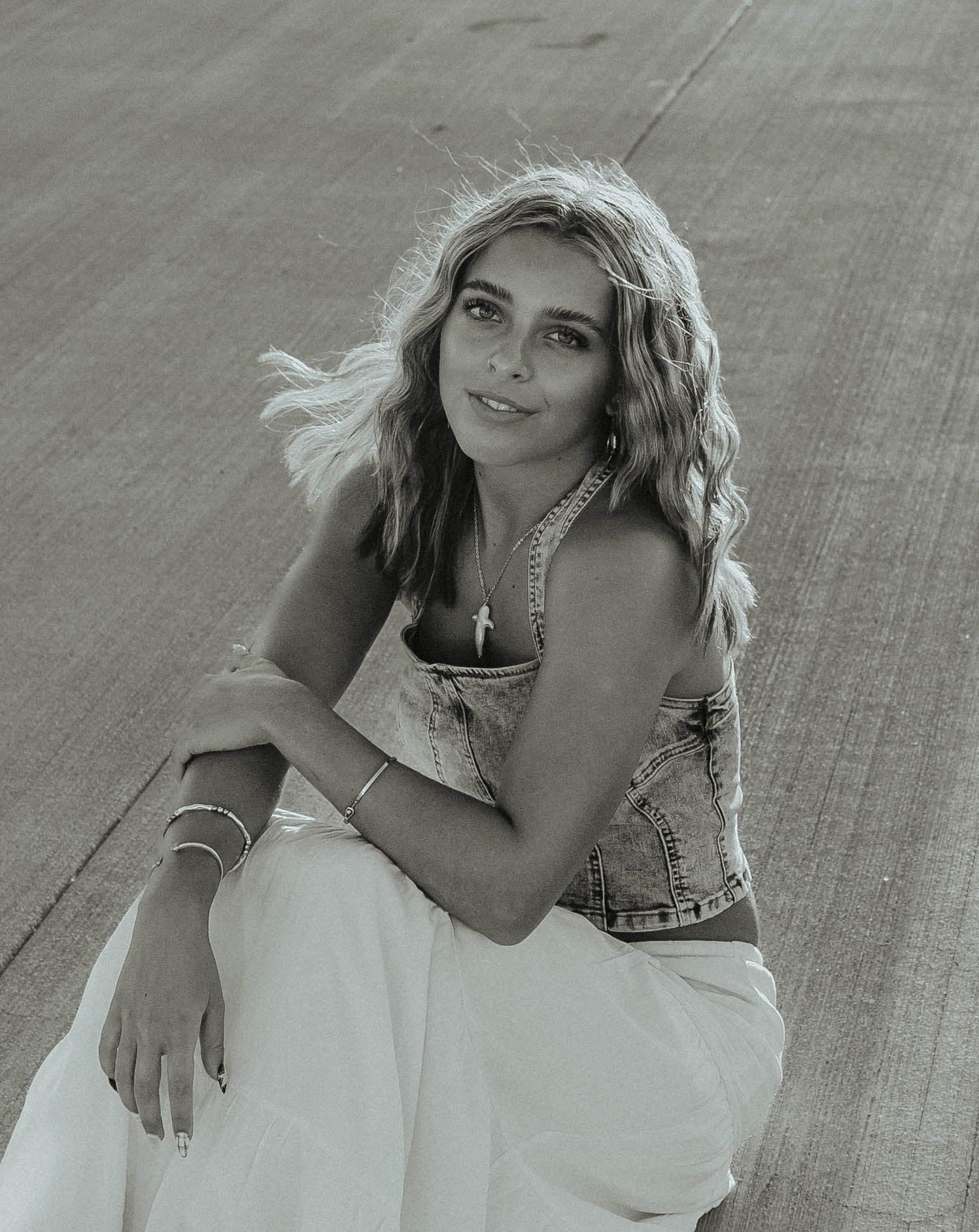 Black and white portrait series showing artistic poses in casual attire against a textured background.