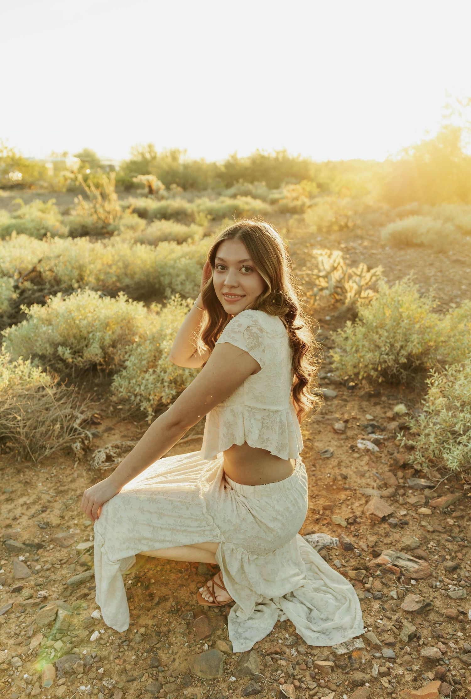 A white dress twirling against a desert landscape during sunset.