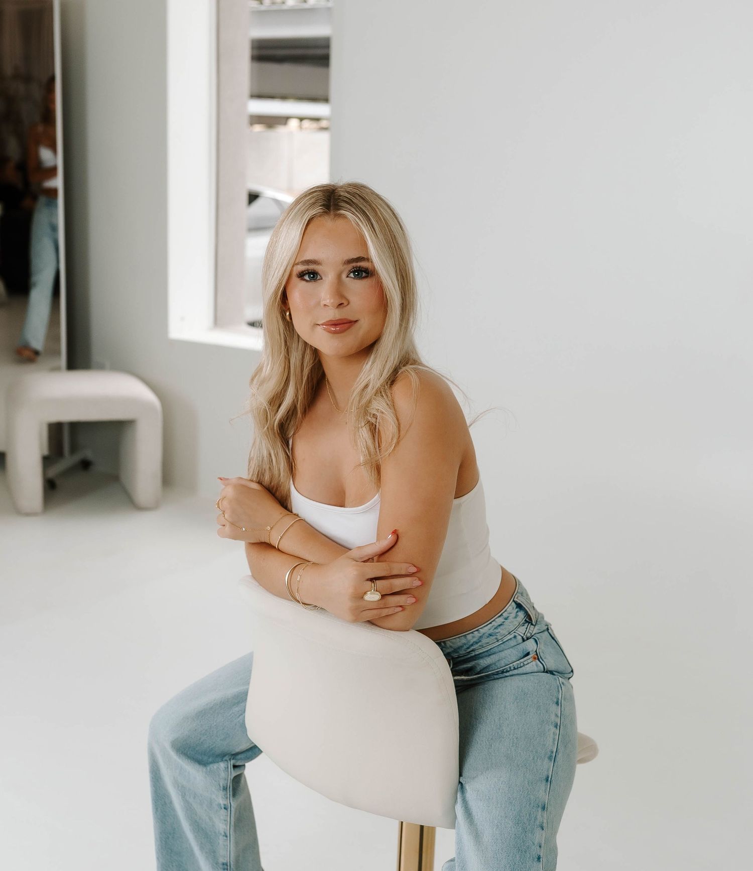 Casual studio portraits on white stool featuring relaxed denim styling.