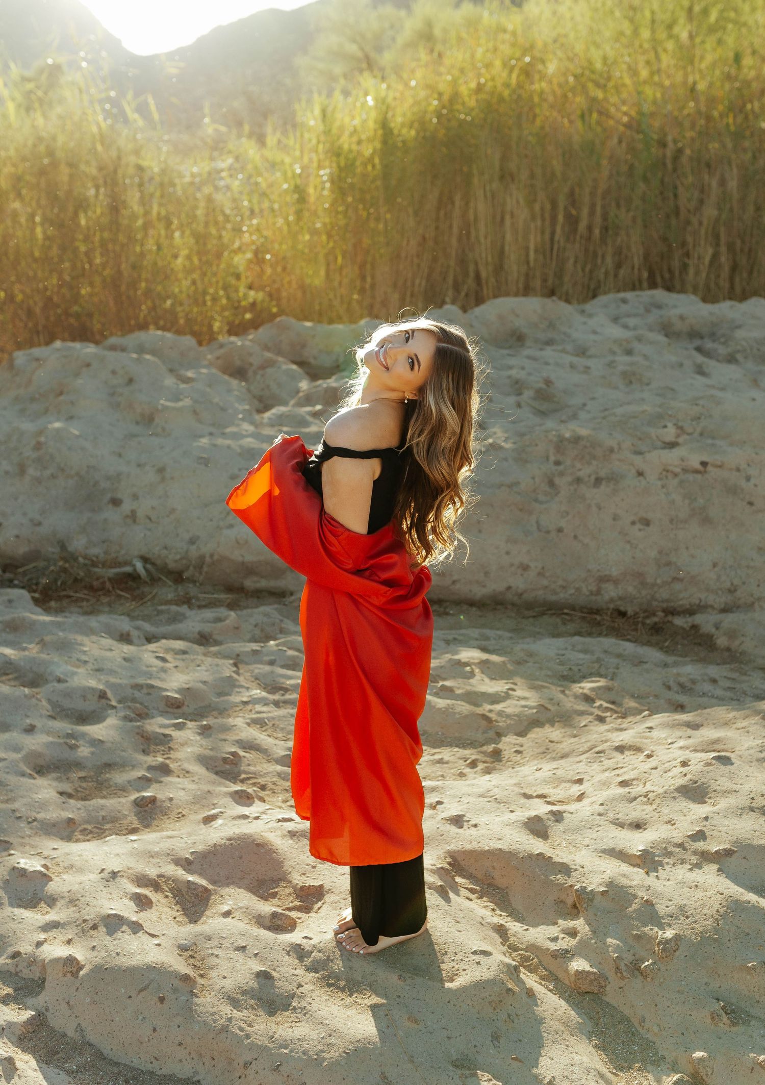 Arizona Senior and Grad photographer capturing cap and gown photos on a gorgeous sandy background
