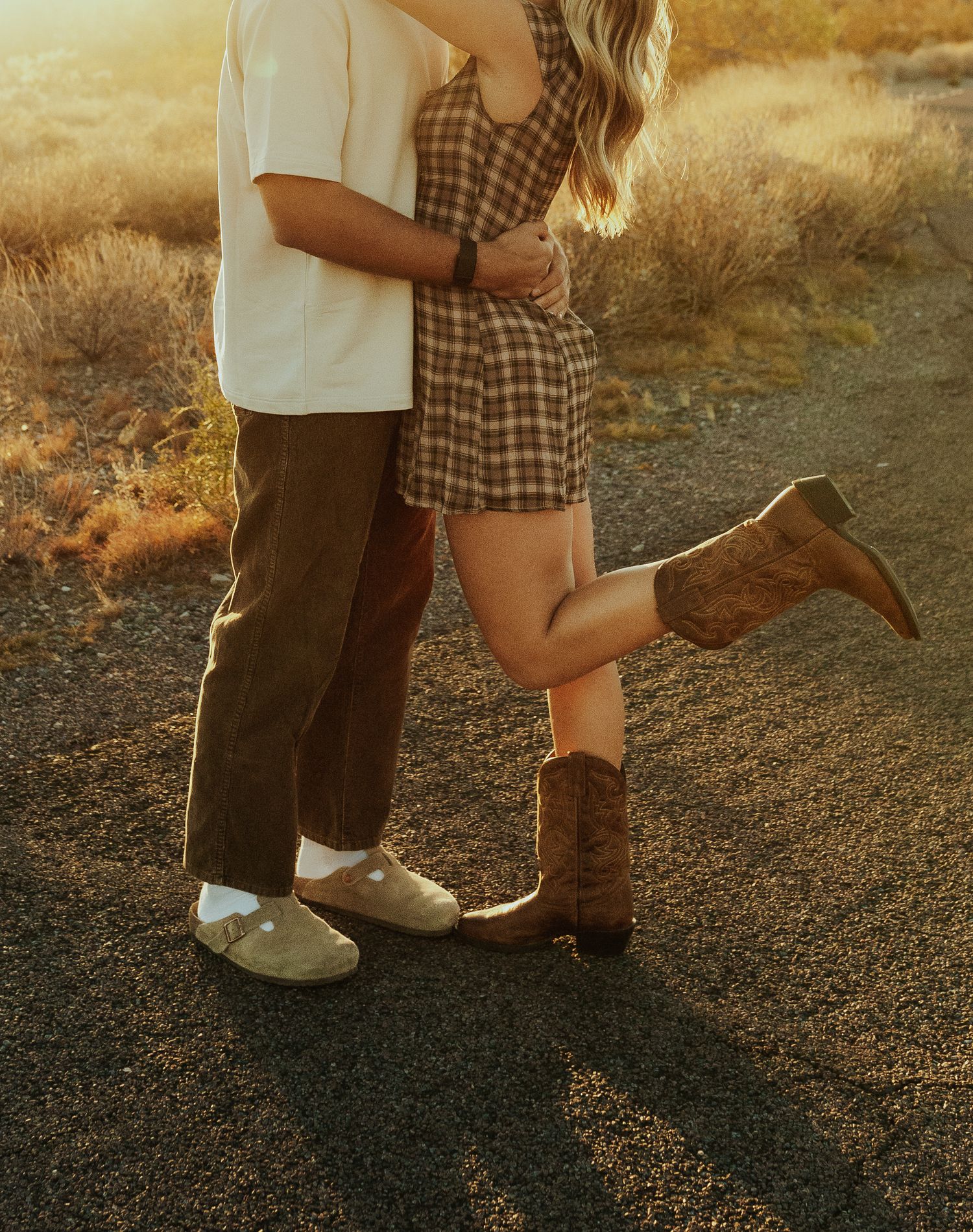 Arizona Cave Creek Western Photographer capture Cowboy boots shown side by side on a gravel path during golden hour sunset.