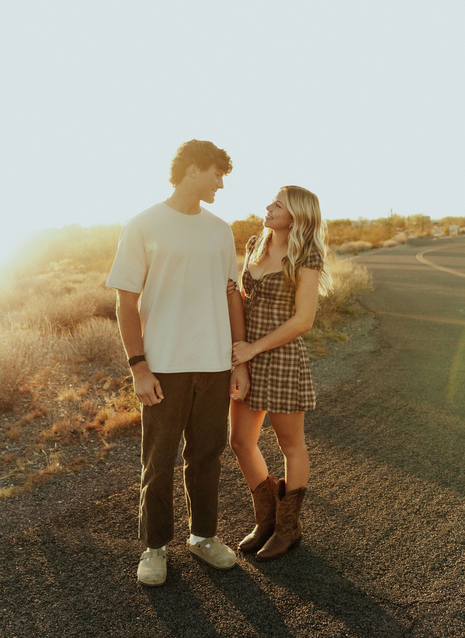 Arizona couple photographer walking together on a dirt path at sunset, captured in multiple romantic silhouetted frames.