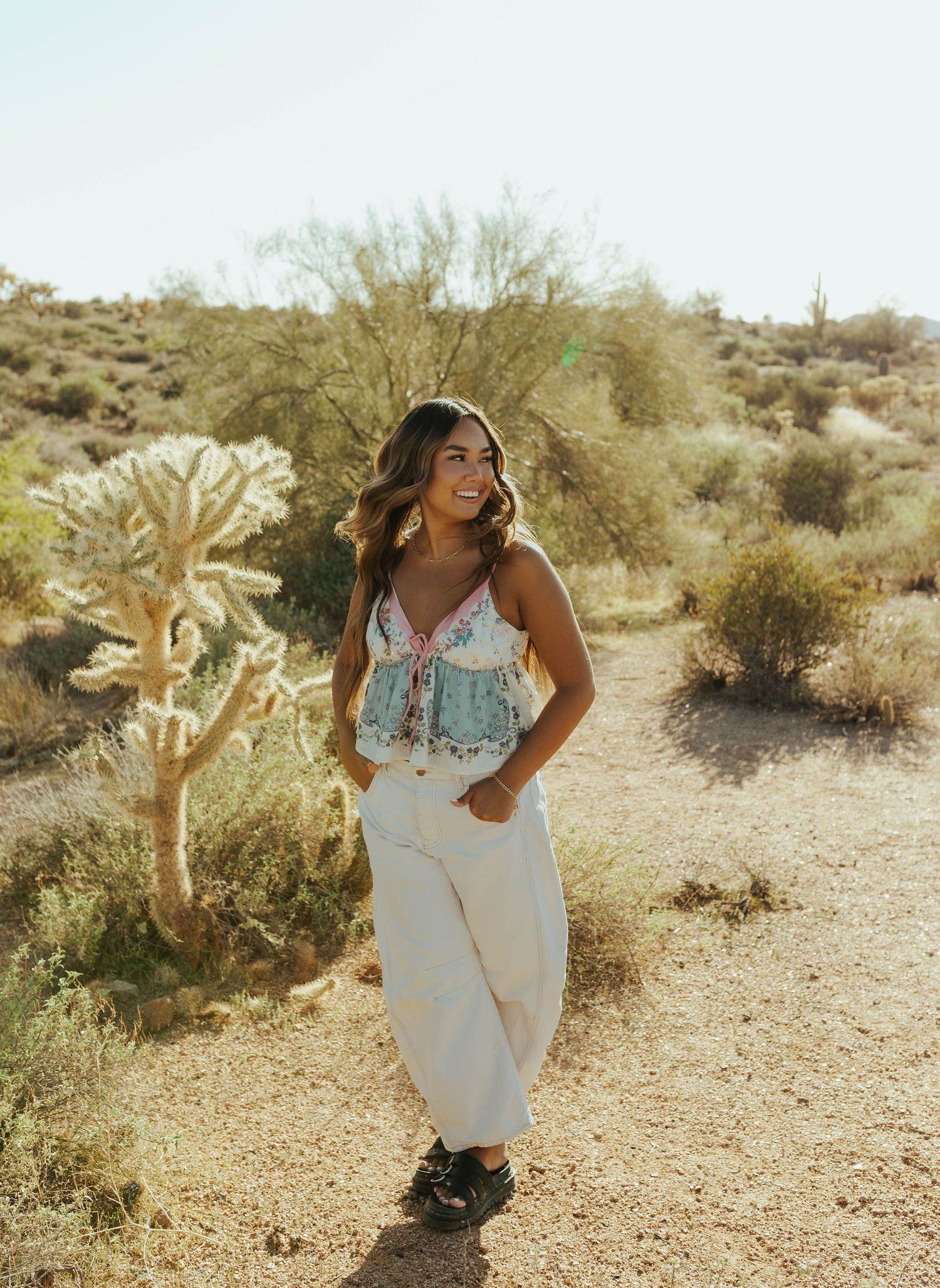 A joyful desert photoshoot featuring casual white attire among desert flora and mountains.