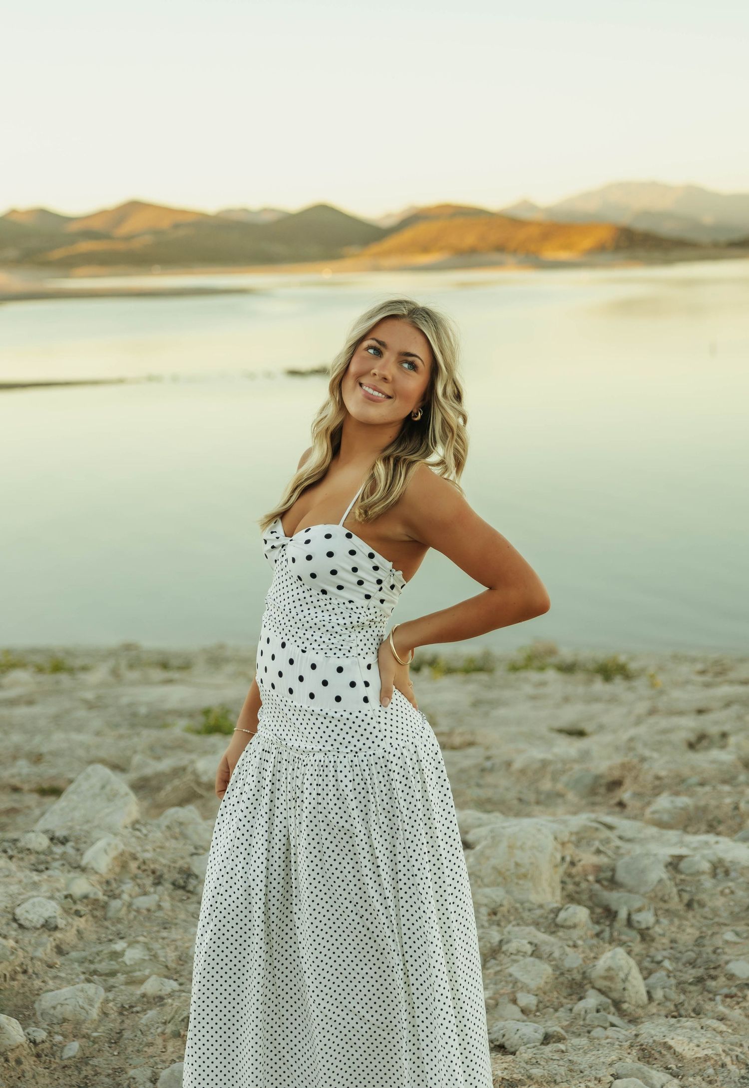 White polka dot dress contrasts beautifully with desert mountain scenery.